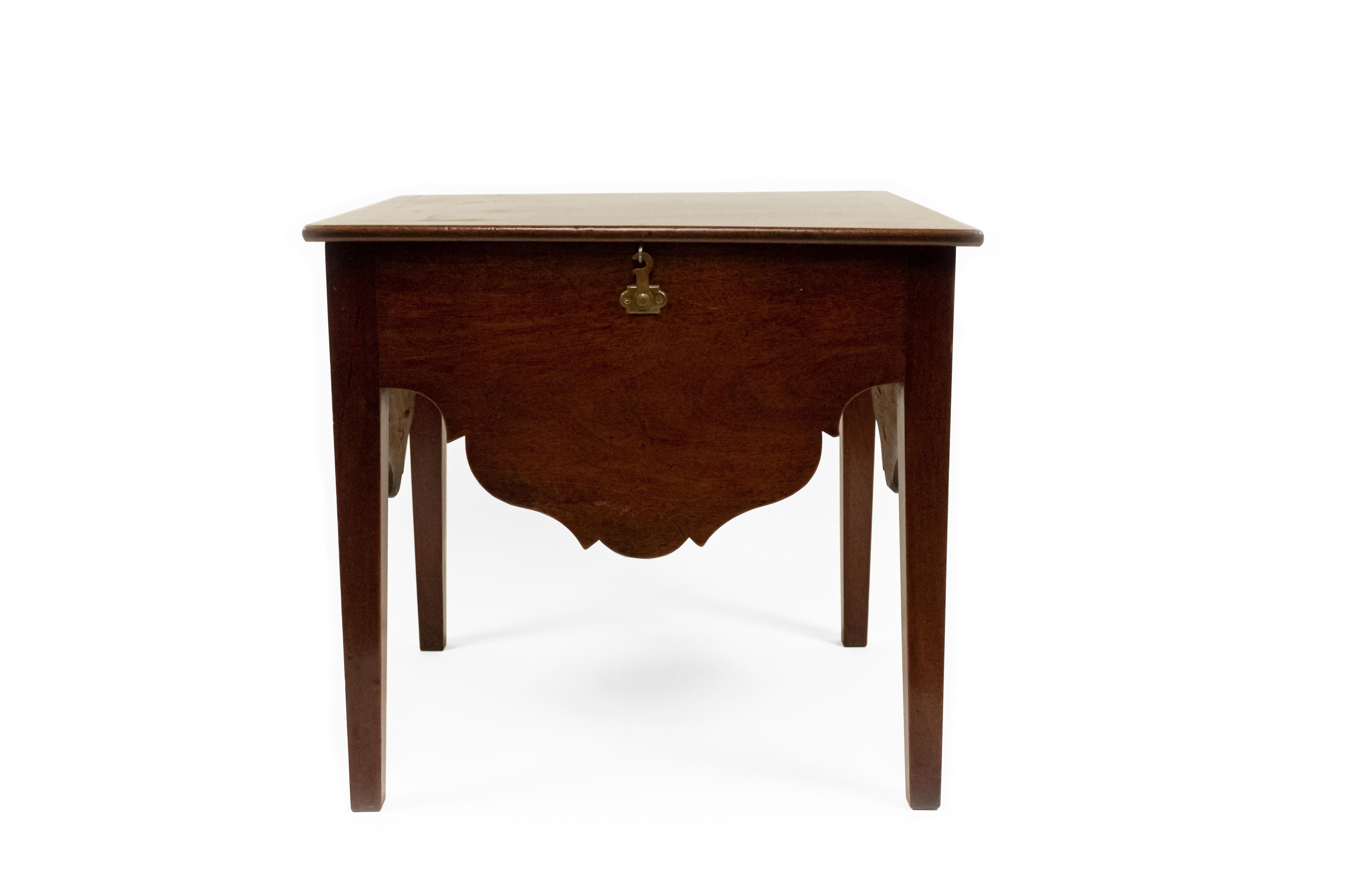 English Georgian (circa 1770) mahogany low end table / box commode with lift top and a shaped lower apron resting on square tapered legs.