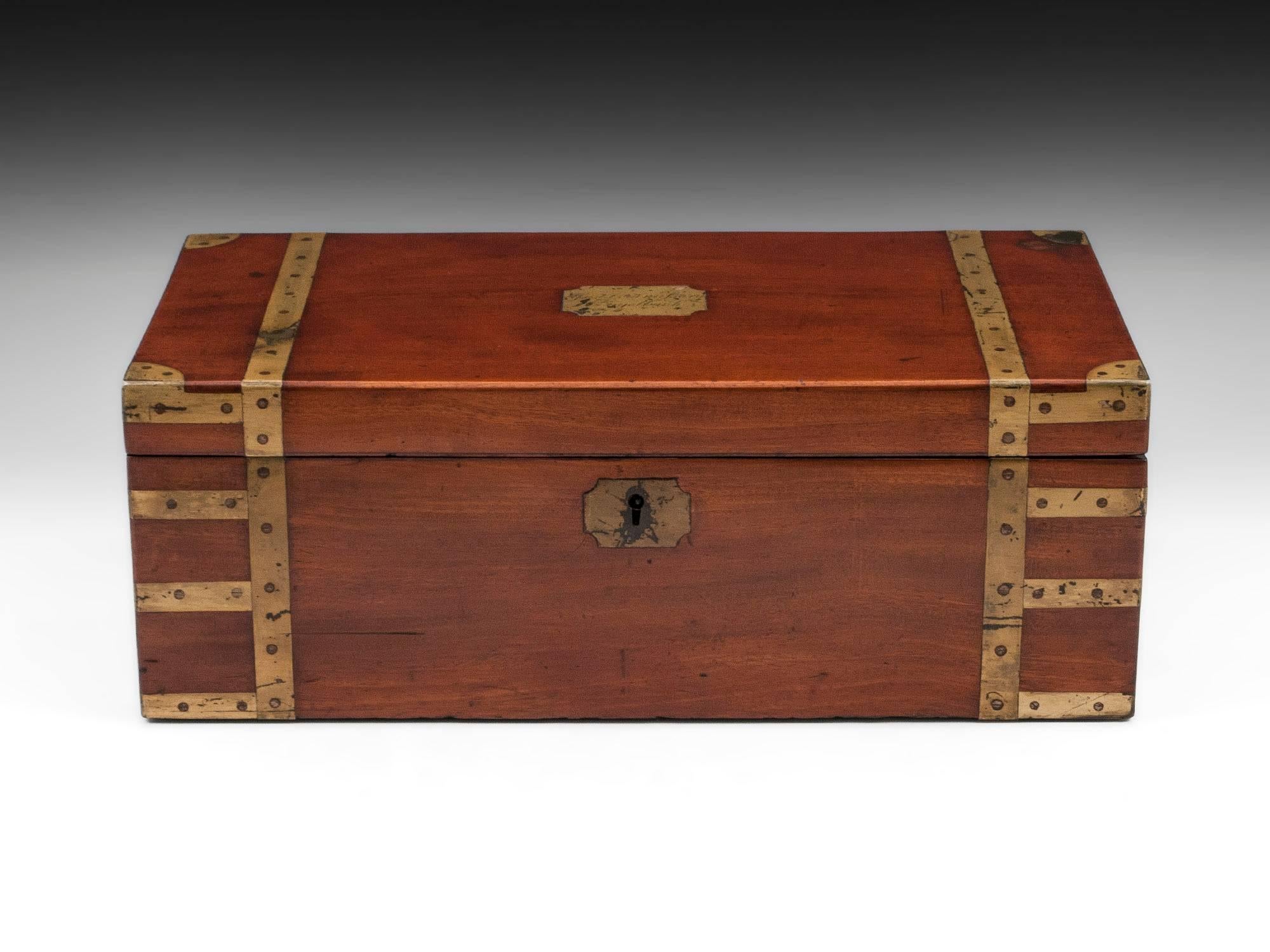 Georgian military Campaign box in solid mahogany with screwed brass strapping and flush-fitting side-handles and side drawer. Solid and functional to the outside, the real interest in this box lies in its interior. It retains its original candle