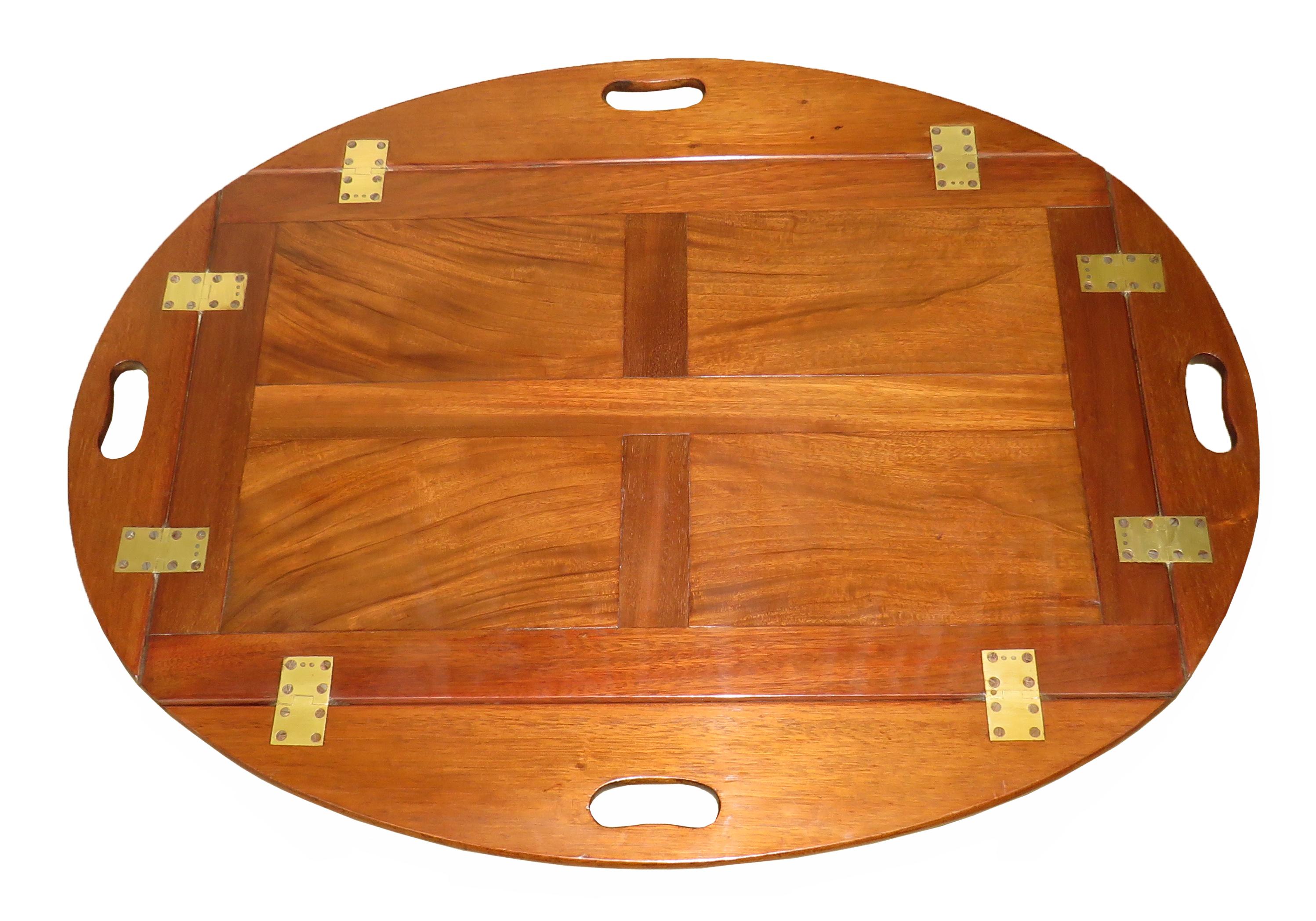 A good quality Georgian mahogany oval butlers tray
Of panelled form having original brass hinges to
Folding sides raised on later square
Tapered leg stand

(Always a great solution to the age old 
problem of there being no such thing a
