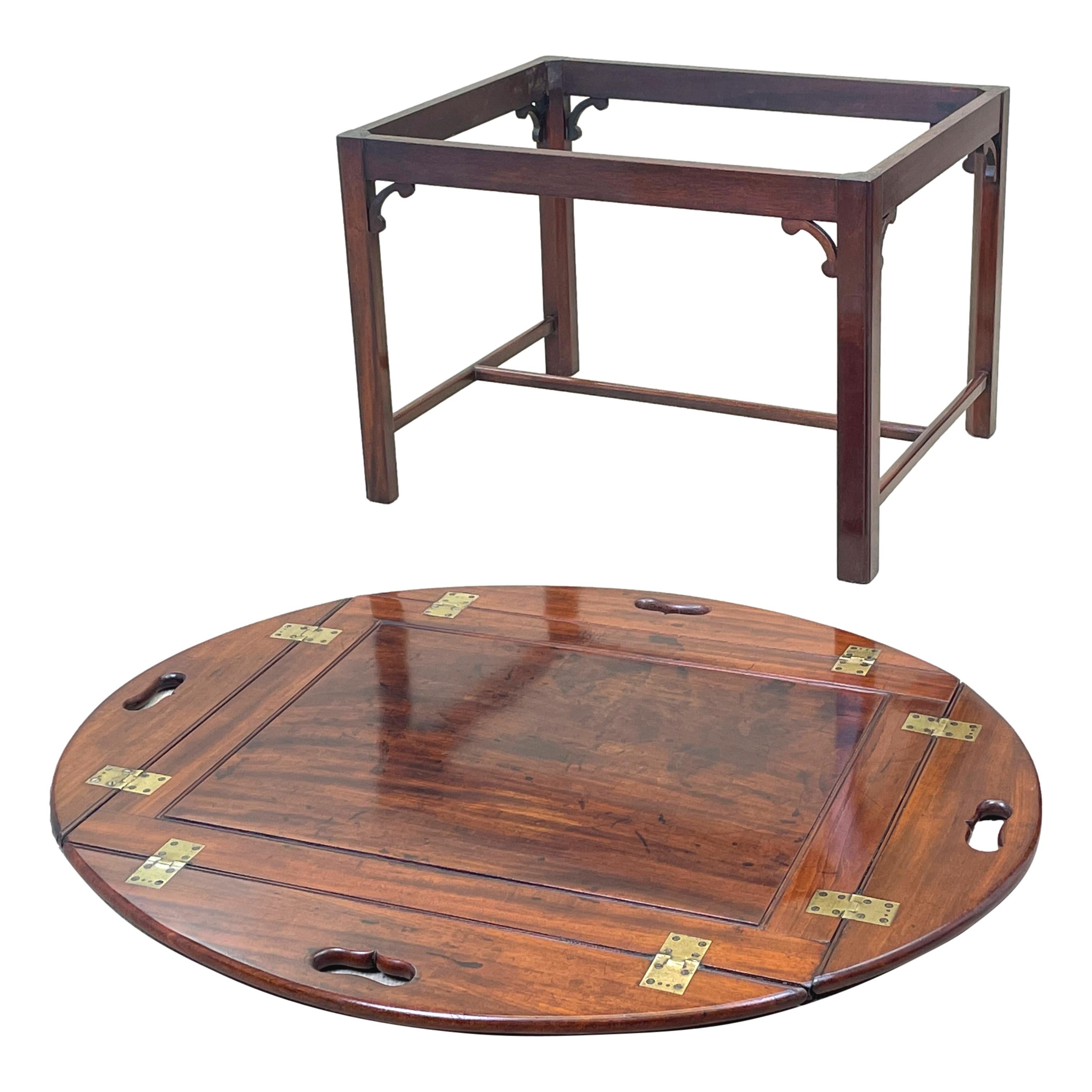 A very good quality georgian mahogany oval butlers
Tray, unusually having single panelled top, with hinged
Folding sides and pierced carrying handles housed on
Later square chamfered leg stand



(Always a great solution to the age