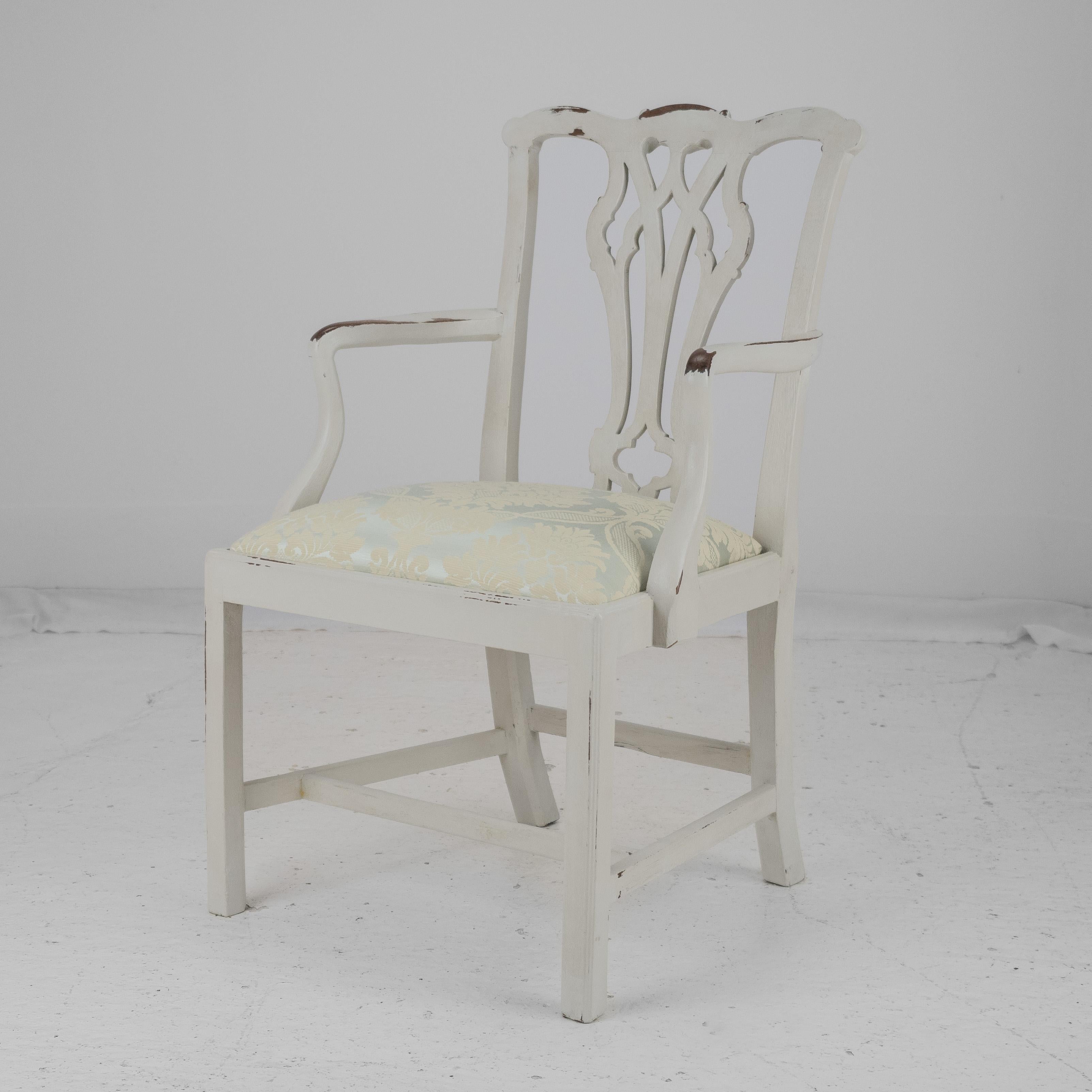 A Georgian period, late 18th century, painted mahogany elbow chair. This armchair in Chippendale taste, features a pierced back splat, drop-in upholstered seat, covered in a quality woven damask pale blue green fabric. Curved open arms. Square front
