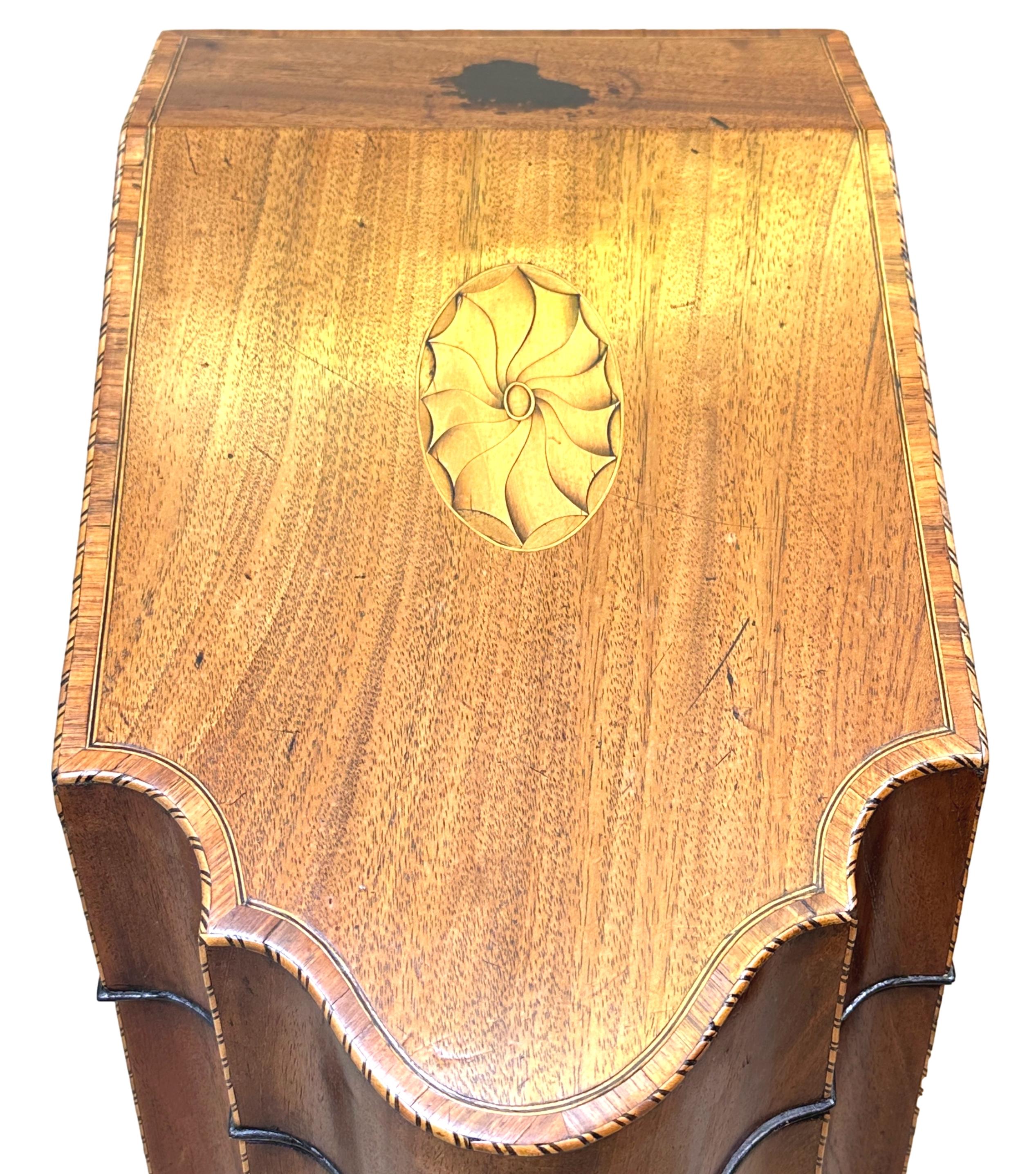 Un par de cajas de caoba de muy buena calidad, del siglo XVIII, época de Jorge III, para cuchillos o cubiertos, de forma típica, con frentes serpentinos y tapas inclinadas magníficamente labradas, con incrustaciones y bandas cruzadas, que revelan