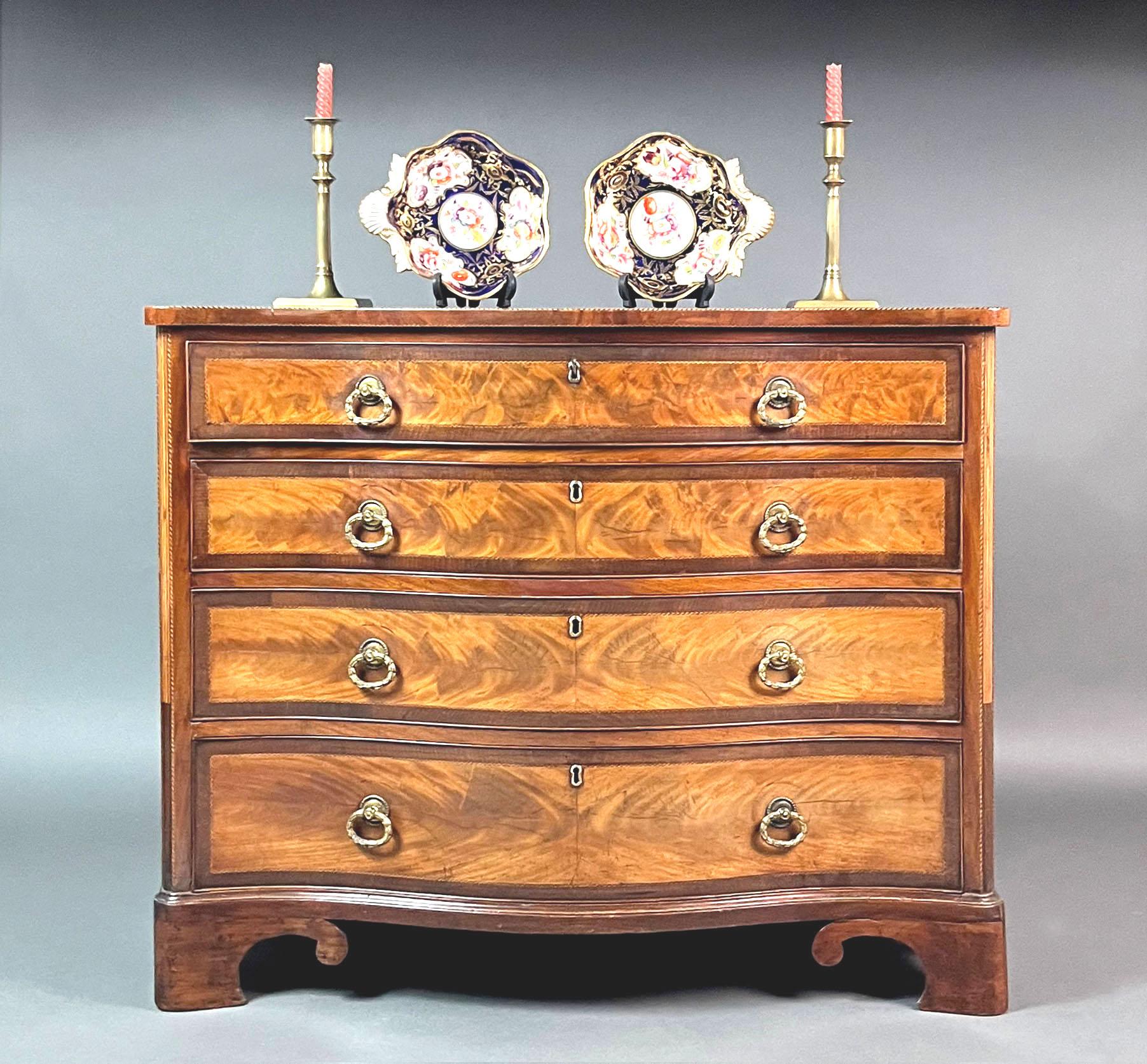Cassettone o commode georgiano in mogano a serpentina
Bella cassettiera o commode a serpentina del periodo Sheraton di Giorgio III in mogano chiaro e splendidamente figurato con attraente incordatura a palo di barbiere e bordatura trasversale in