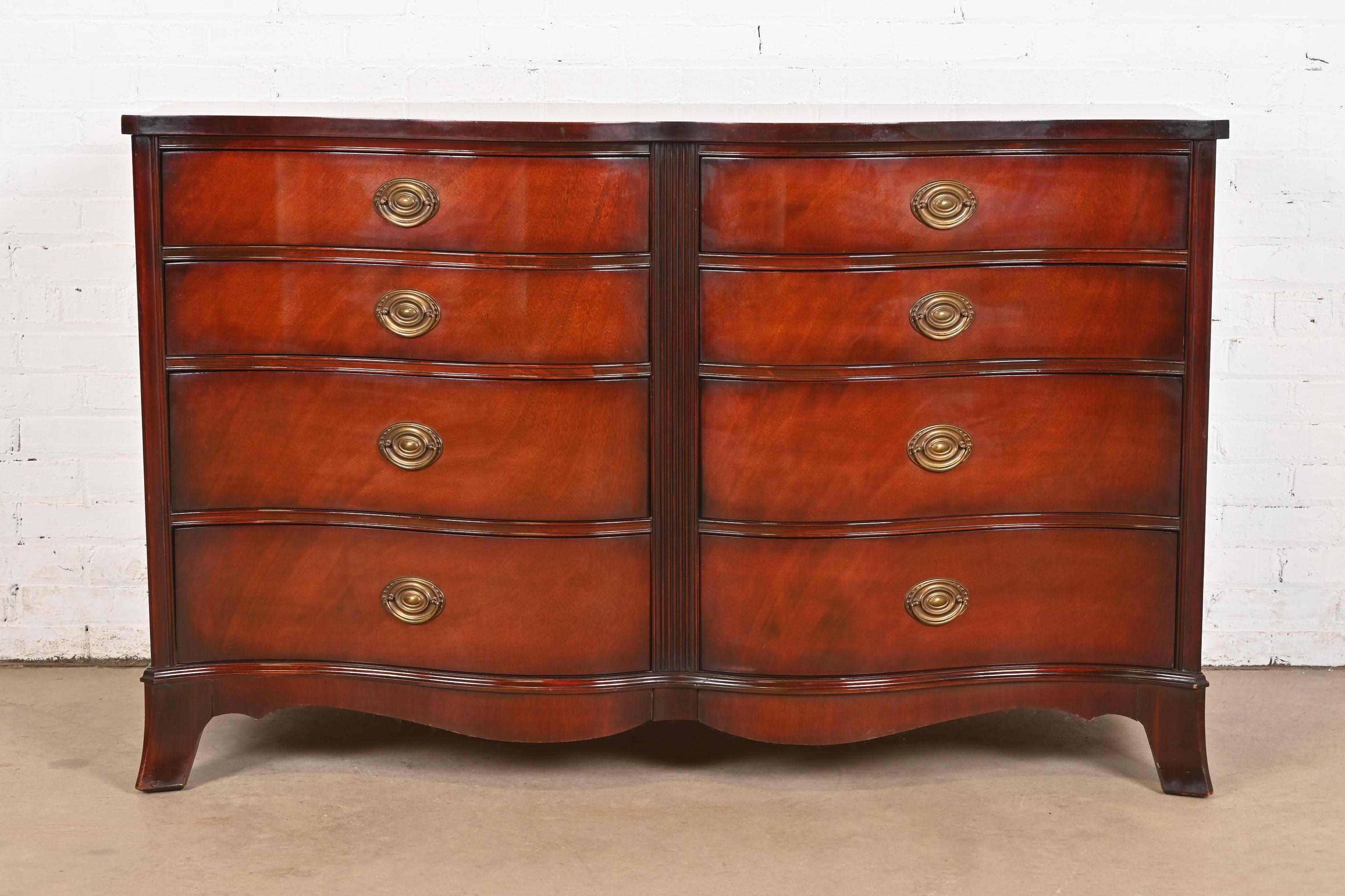 An exceptional Georgian or Regency style serpentine front eight-drawer double dresser or chest of drawers

By White Furniture

USA, Circa 1960s

Carved mahogany, with original brass hardware.

Measures: 57