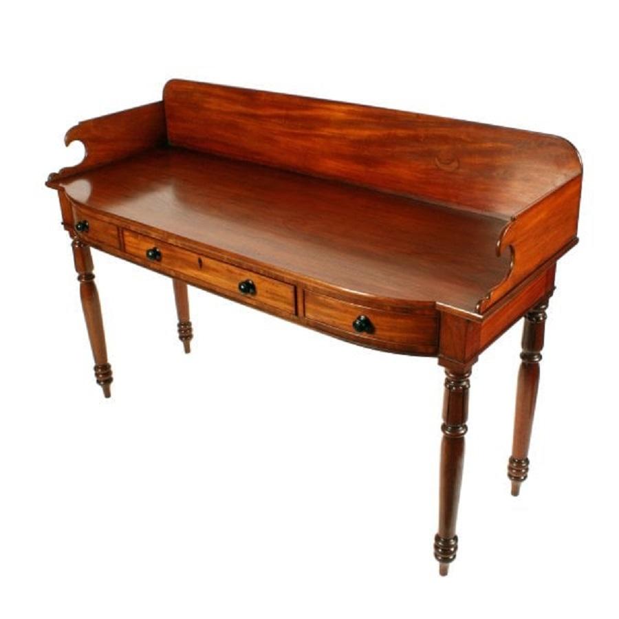 An early 19th century Georgian mahogany serving table.

The table has a slightly bowed front and a gallery back with shaped ends.

The table has a central long drawer with dummy drawers either side and all have turned ebony knob handles.

The