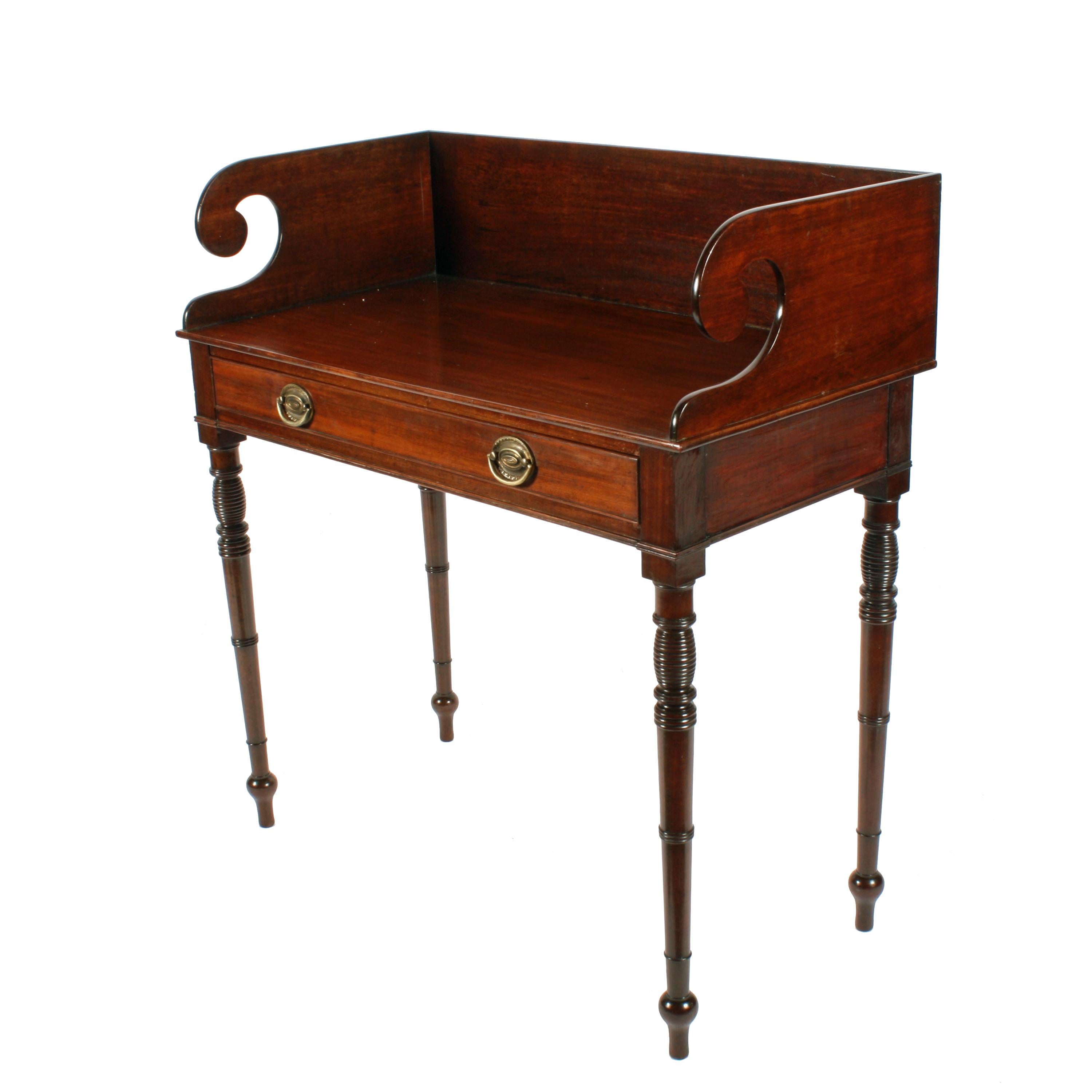 A Georgian mahogany one drawer side table.

The table has a shaped gallery back and four turned tapering legs with decorative ring turned details.

The long slim drawer is lined with solid mahogany, the drawer fronts have a cock bead edge and