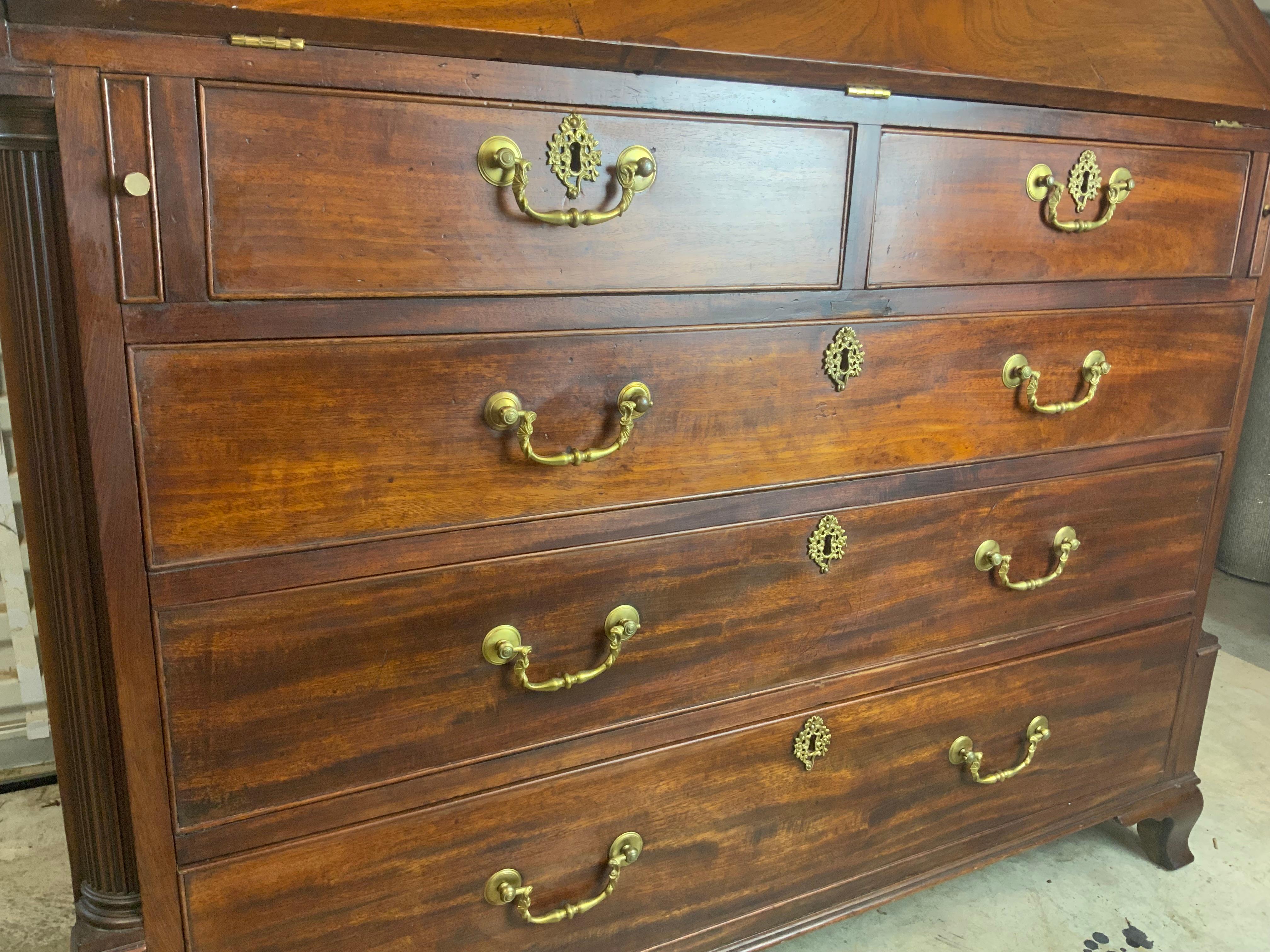 A very attractive Georgian Mahogany Secretary Desk with reeded quarter columns sitting on splayed ogee feet.  Mahogany, pine and Quarter saw Oak secondary woods.  Original hardware and leather interior on inside writing surface with several small
