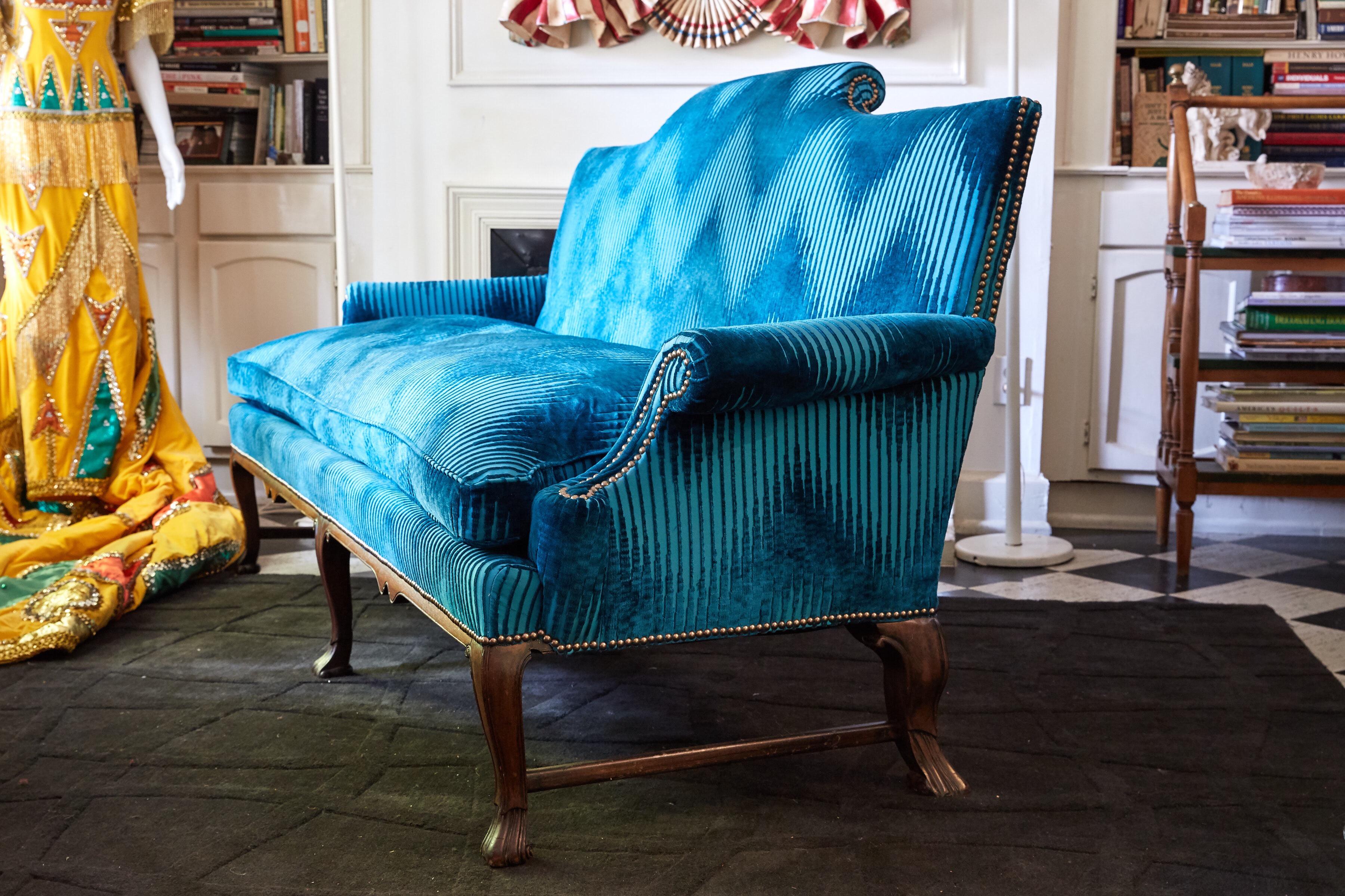 19th century English sofa in the Georgian style with a carved mahogany frame. The sofa has a cushion back and one cushion down seat. It has been reupholstered in turquoise Jim Thompson Bargello fabric and accented with rose gold nailheads.