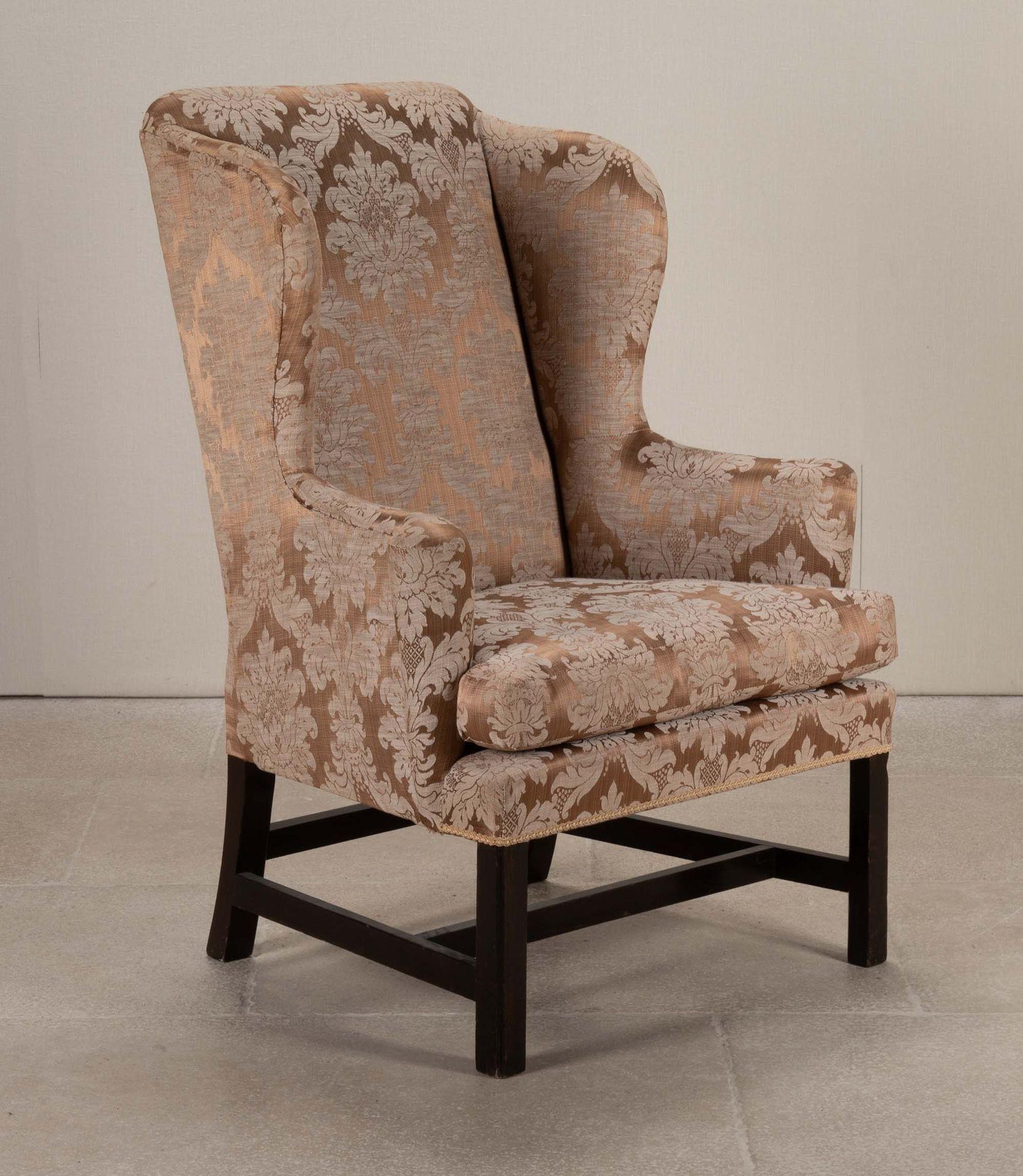 Poltrona georgiana con schienale ad ala imbottito in mogano e gambe quadrate.