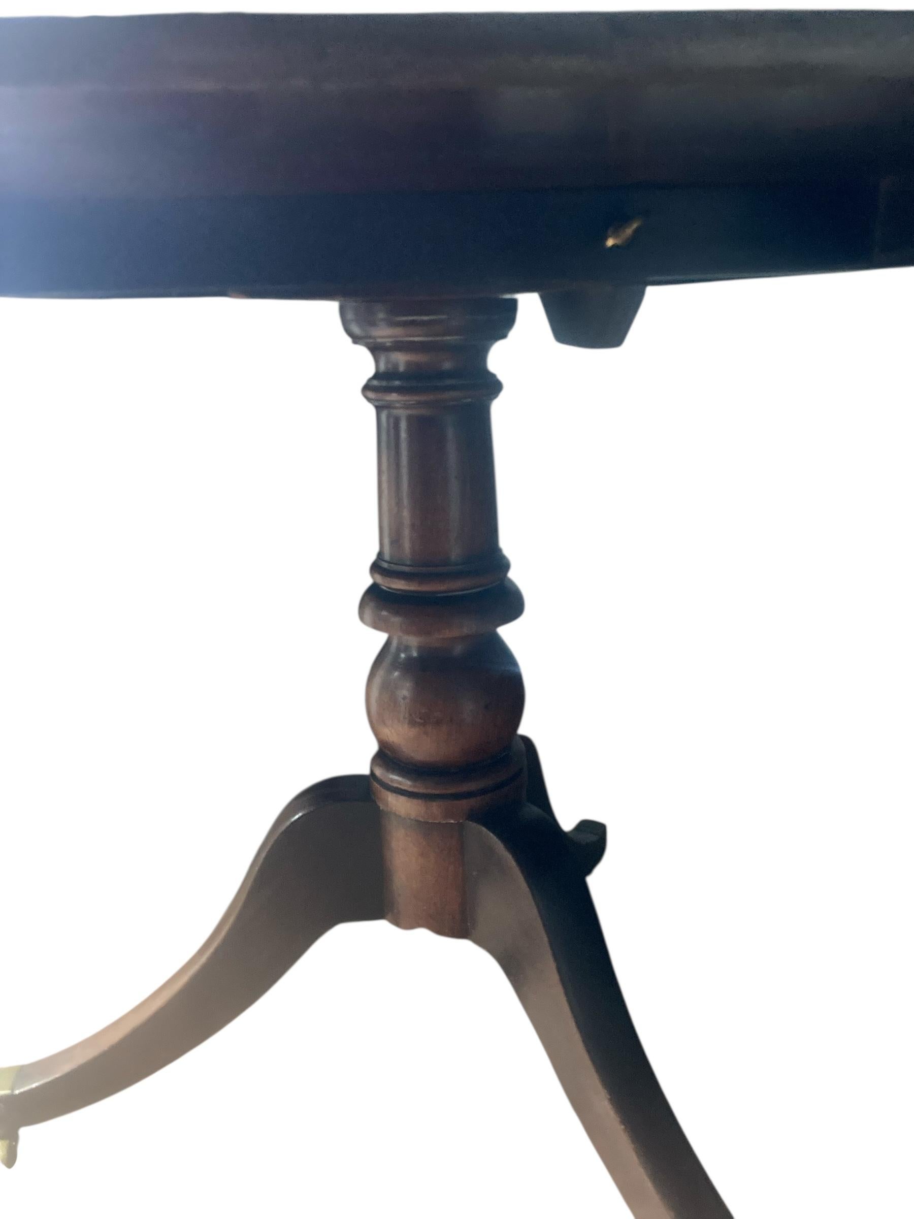 Table à plateau basculant en acajou de bonne qualité, d'époque géorgienne, reposant sur trois pieds à ébrasement, avec embouts en laiton et pieds à roulettes. Dotée d'un plateau inclinable, cette jolie table peut être rangée en position verticale