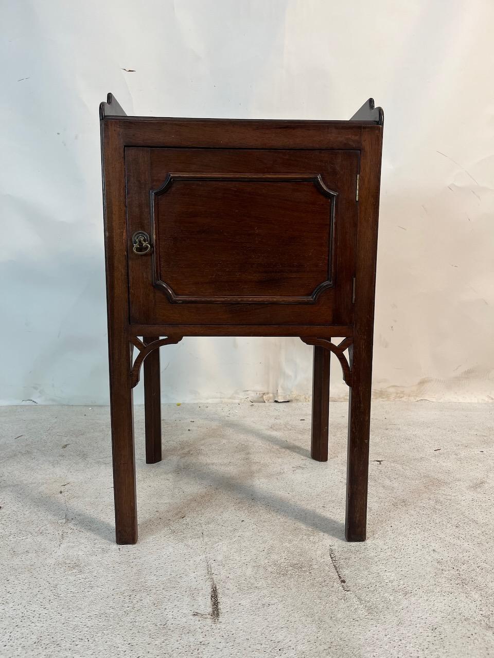 Armario de viaje georgiano de caoba. Armario orinal de una puerta con calado Chippendale.  Asas de mano en la bandeja superior para facilitar el transporte.
Pestillo original de latón.
