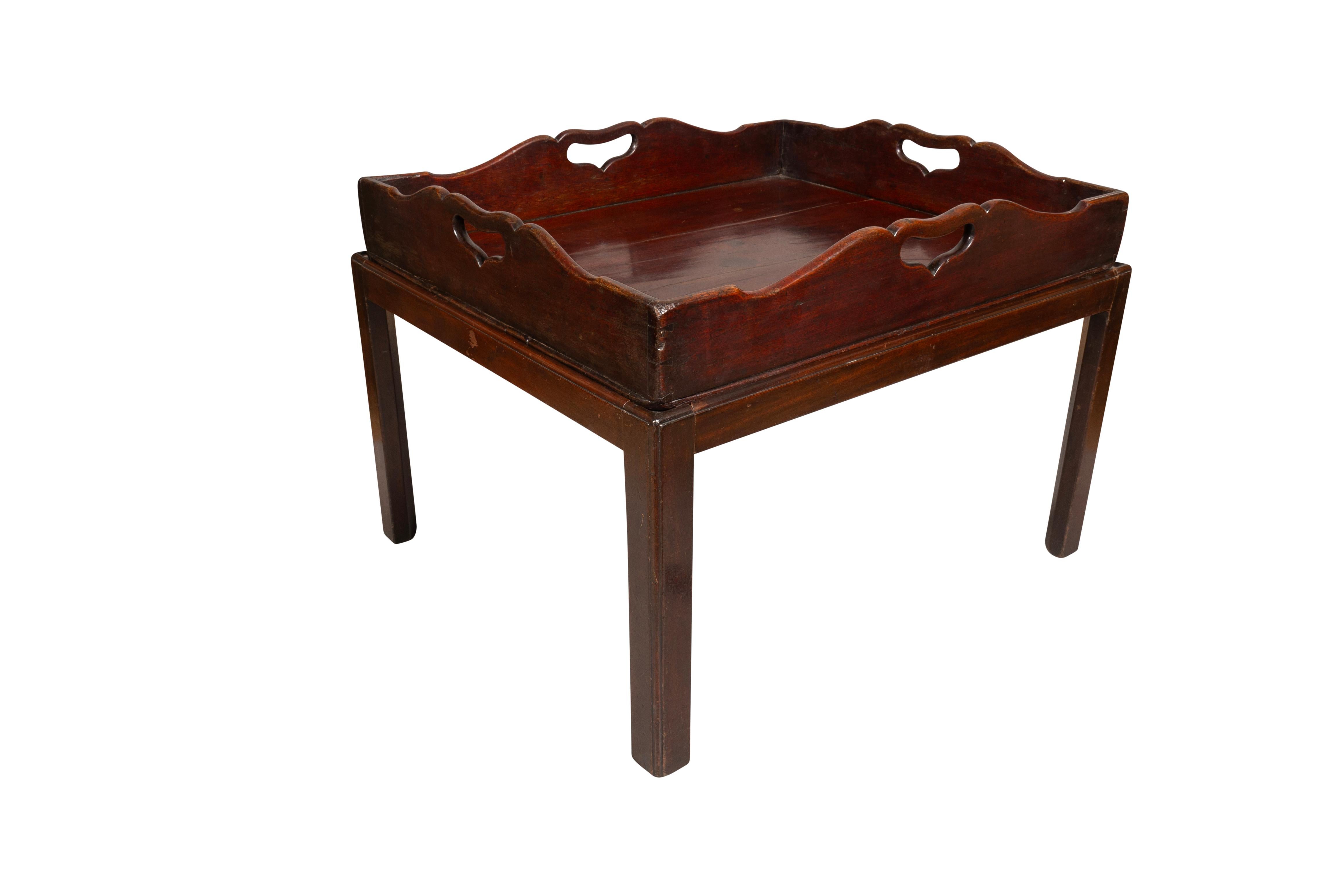 Rectangular tray with shaped gallery and cut out handholds, later mahogany base with square section legs.