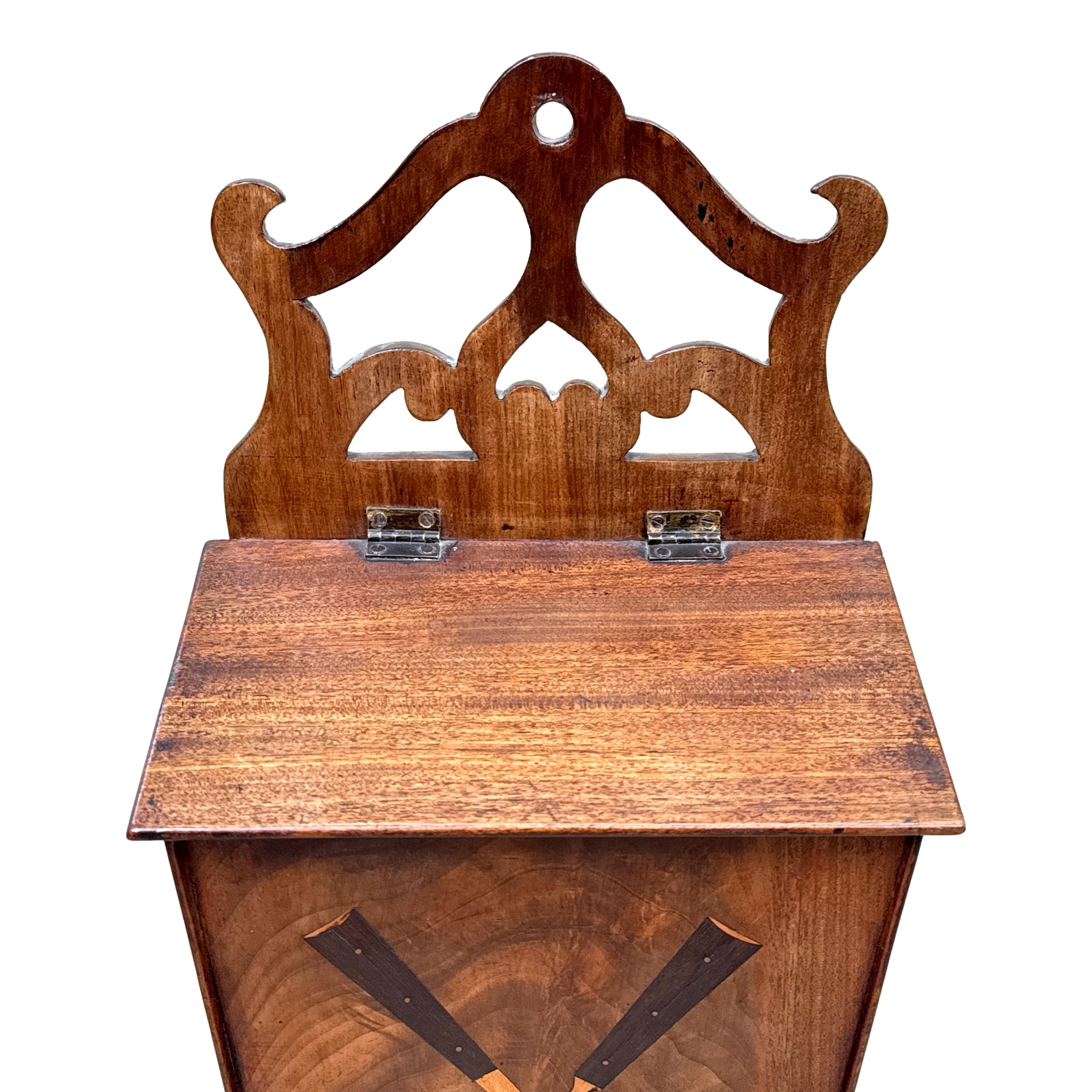 A Very Attractive And Unusual George III Period Mahogany Wall Hanging Candle Box, Or Cutlery Box, Having Wonderful Pierced Fretwork Design To Top, Over Sloping Hinged Lid And Well Figured Elegant Tapered Front Inlaid With Knife And Fork