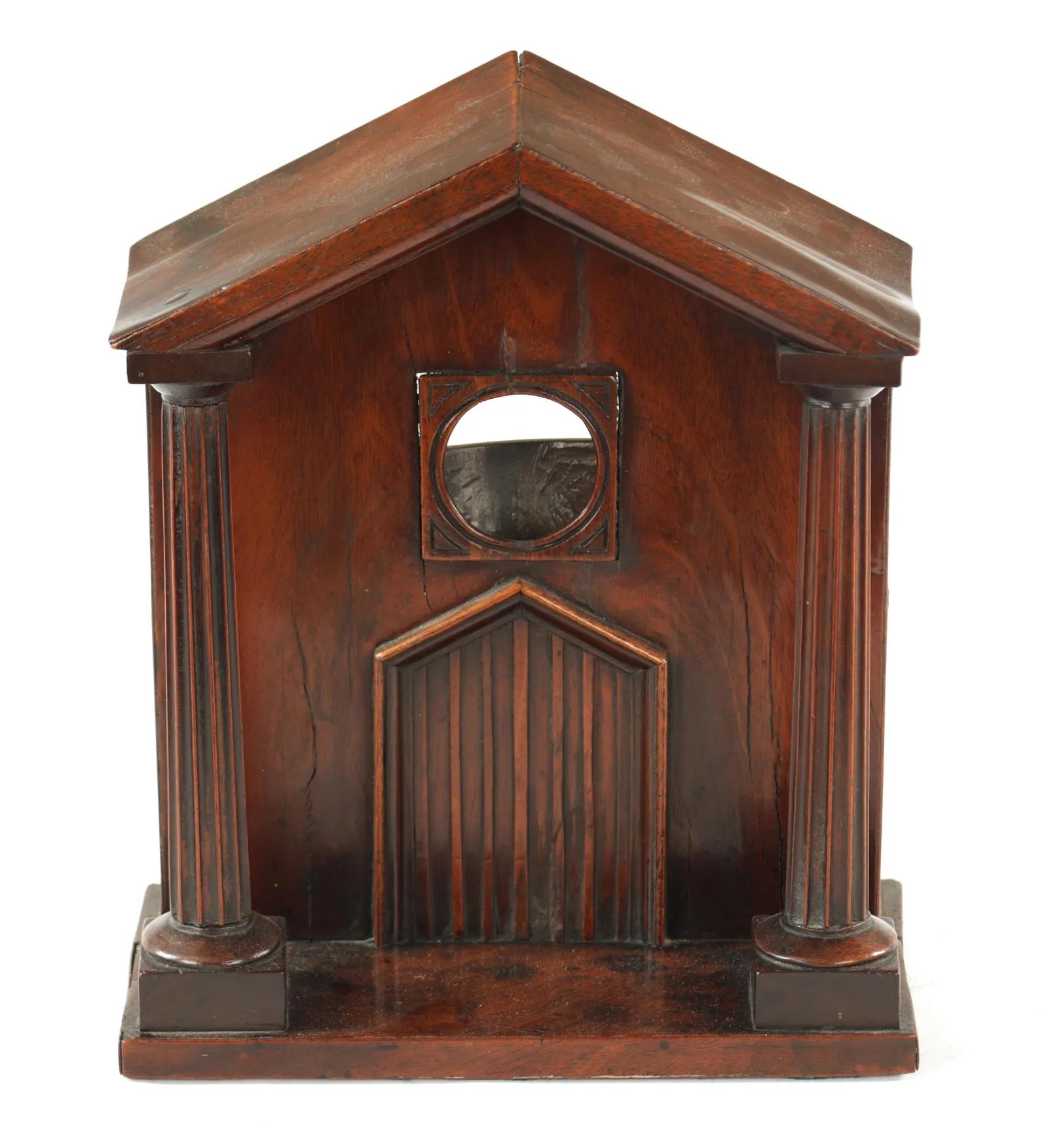 George III mahogany watch hutch of architectural form having fluted columns on a stepped base and supporting a gabled roof. The setback facade with a double door below a circular 