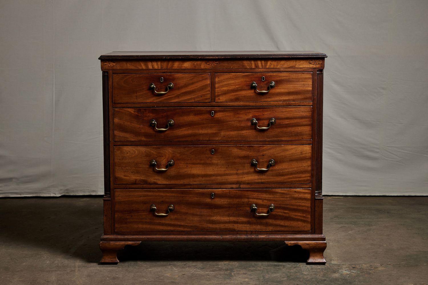 Georgian marquetry decorated chest of drawers ca.1780. Rectangular top with inlaid medallions. The case has five drawers flanked by fluted quarter columns rising on bracket feet.
 