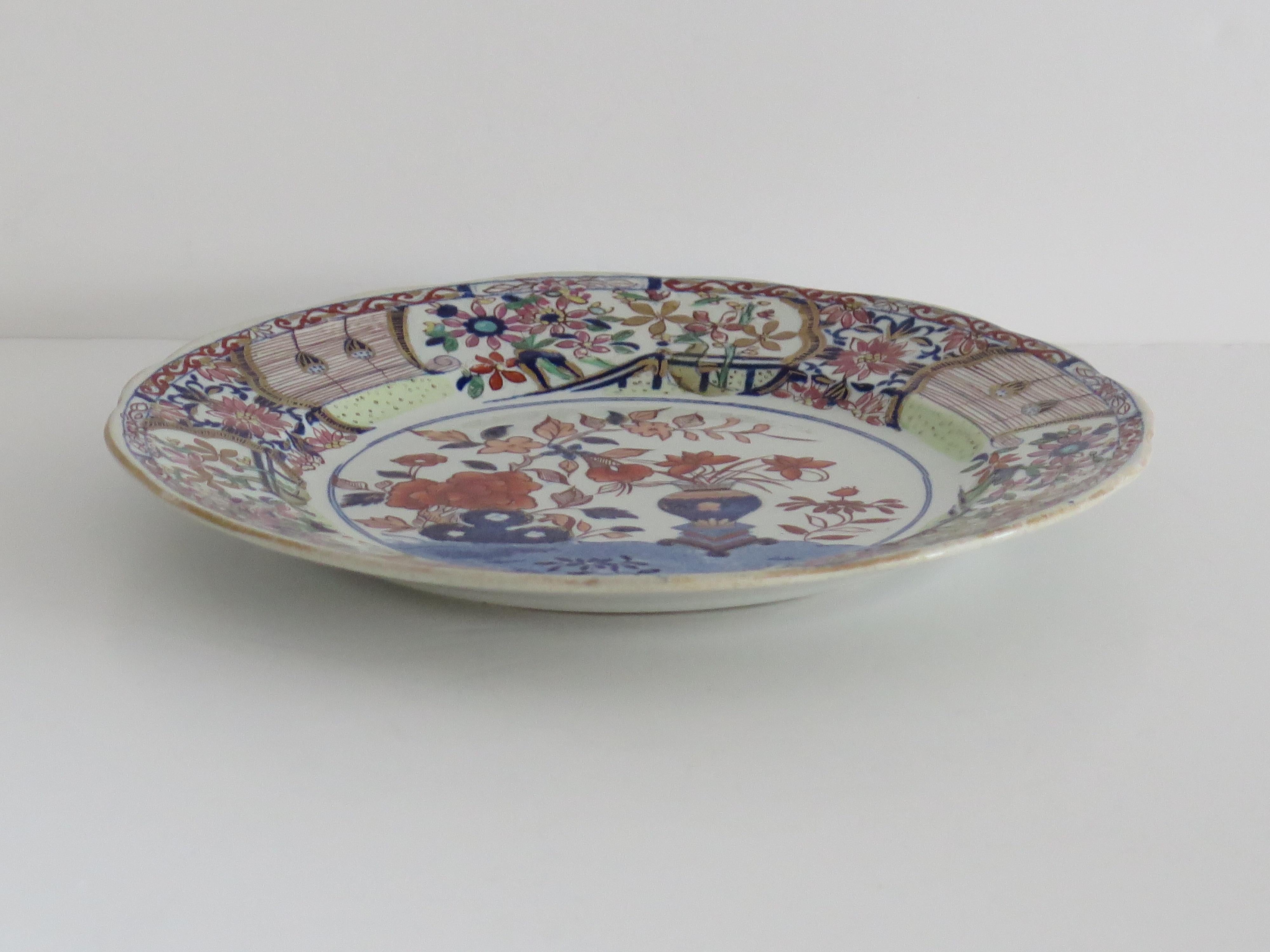 This is a very decorative ironstone pottery Large Dinner Plate produced by the Mason's factory at Lane Delph, Staffordshire, England, circa 1818.

The plate is circular with a wavy indented edge & moulded floral detail to the inner rim edge .

This