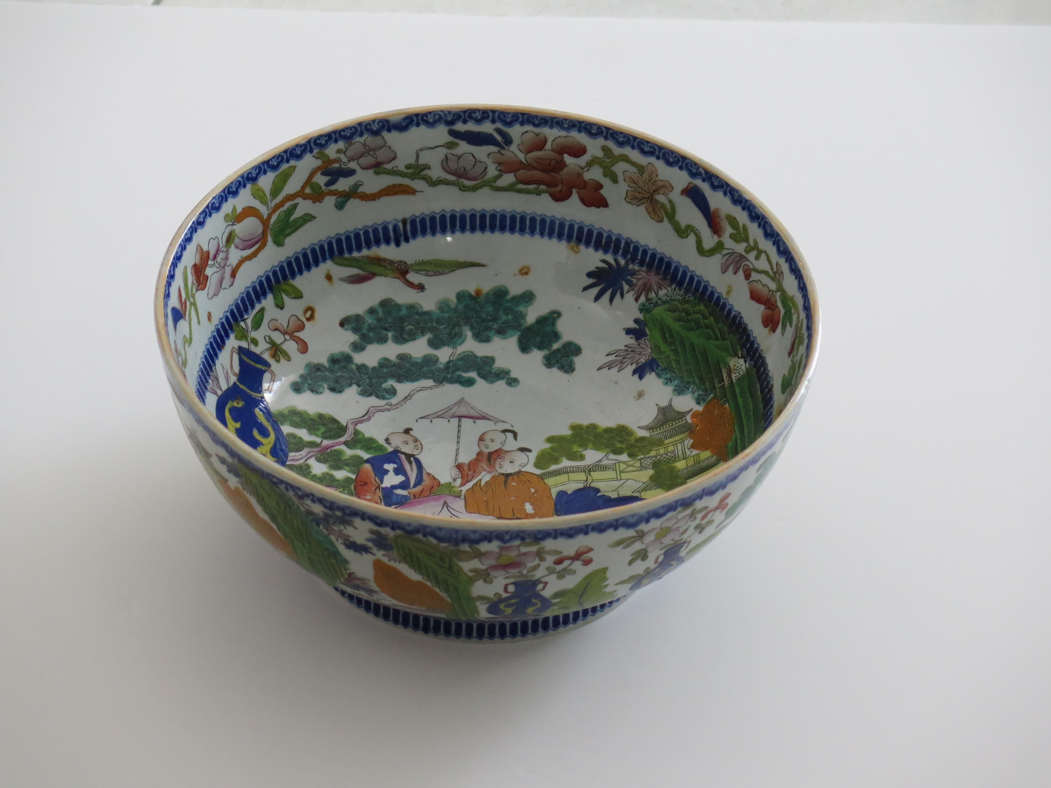 This is a large ironstone pottery Footed Punch Bowl in the rare Mogul chinoiserie people pattern produced by the Mason's factory at Lane Delph, Staffordshire, England, during the late Georgian period, Circa 1818.

This is a large and rare piece.