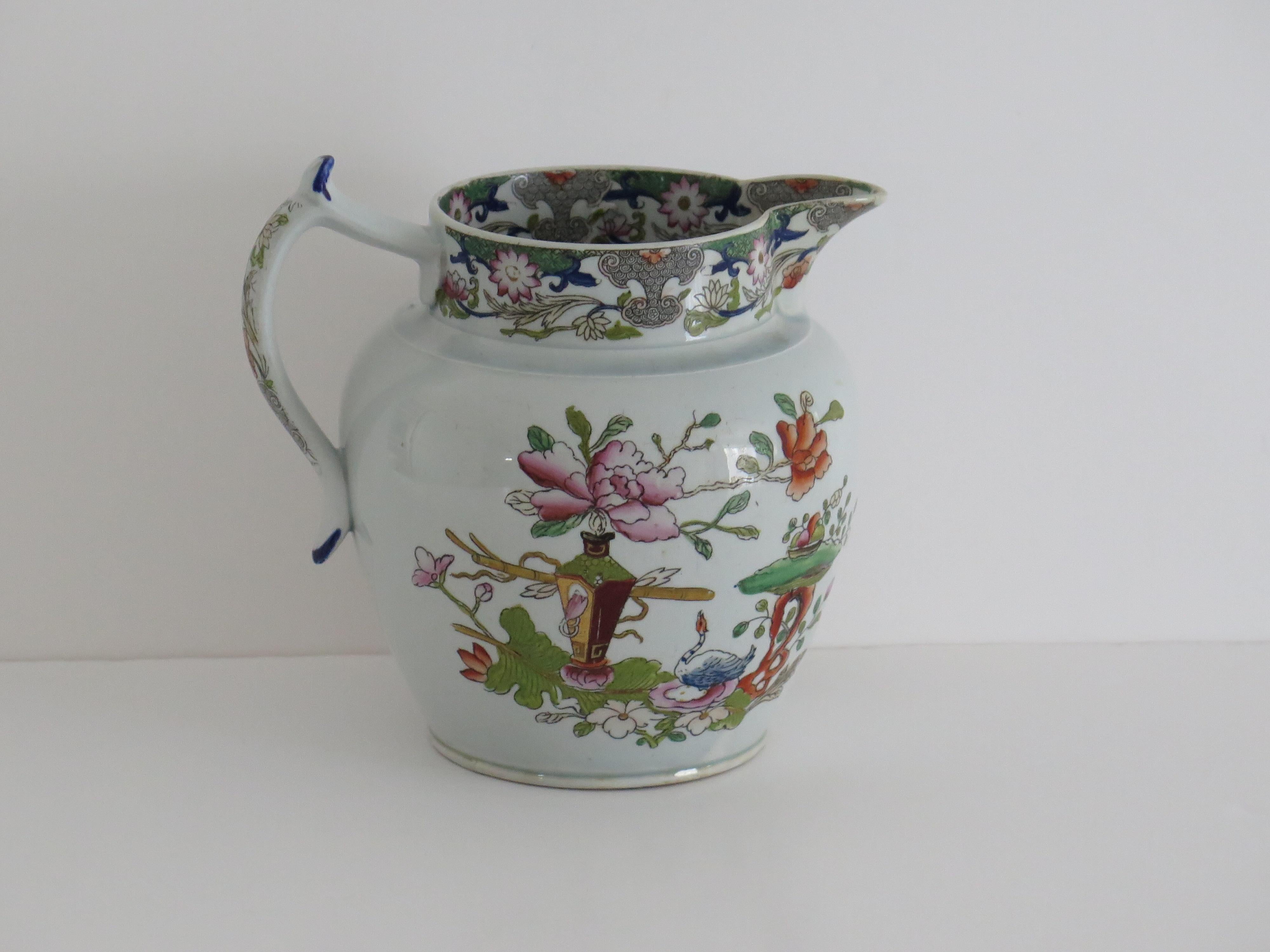 Il s'agit d'une cruche ou d'un pichet en pierre de fer fabriqué par l'usine Mason's à Lane Delph, Staffordshire, Angleterre. Il est décoré du motif de table et de pot de fleurs, entièrement estampillé à la base et datant de la première période de