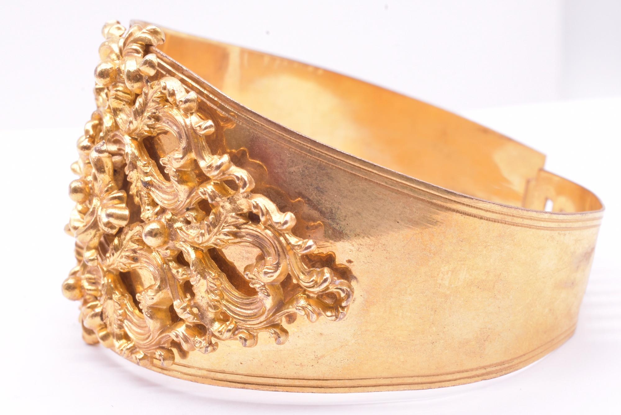 Dramatic metal Georgian cuff bracelet of rolled gold, with slots to adjust the sizing. With its fancy hand worked decorative baroque design bolted to the bracelet, this stylish cuff makes a substantial impact. Leave it to the Georgians to design
