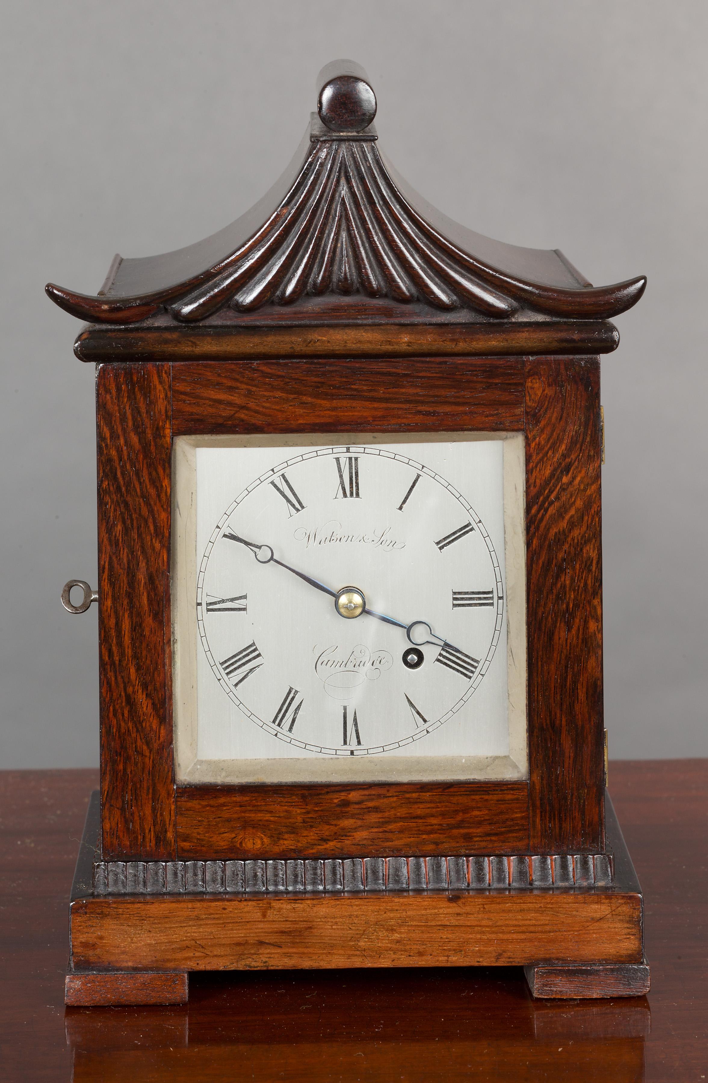 Georgian mahogany miniature bracket clock surmounted by a pagoda top with dentil moulding standing on four pad feet.

Silvered dial with Roman numerals and original ‘blued’ steel hands signed Watson & Son, Cambridge.

Eight day Fusee movement