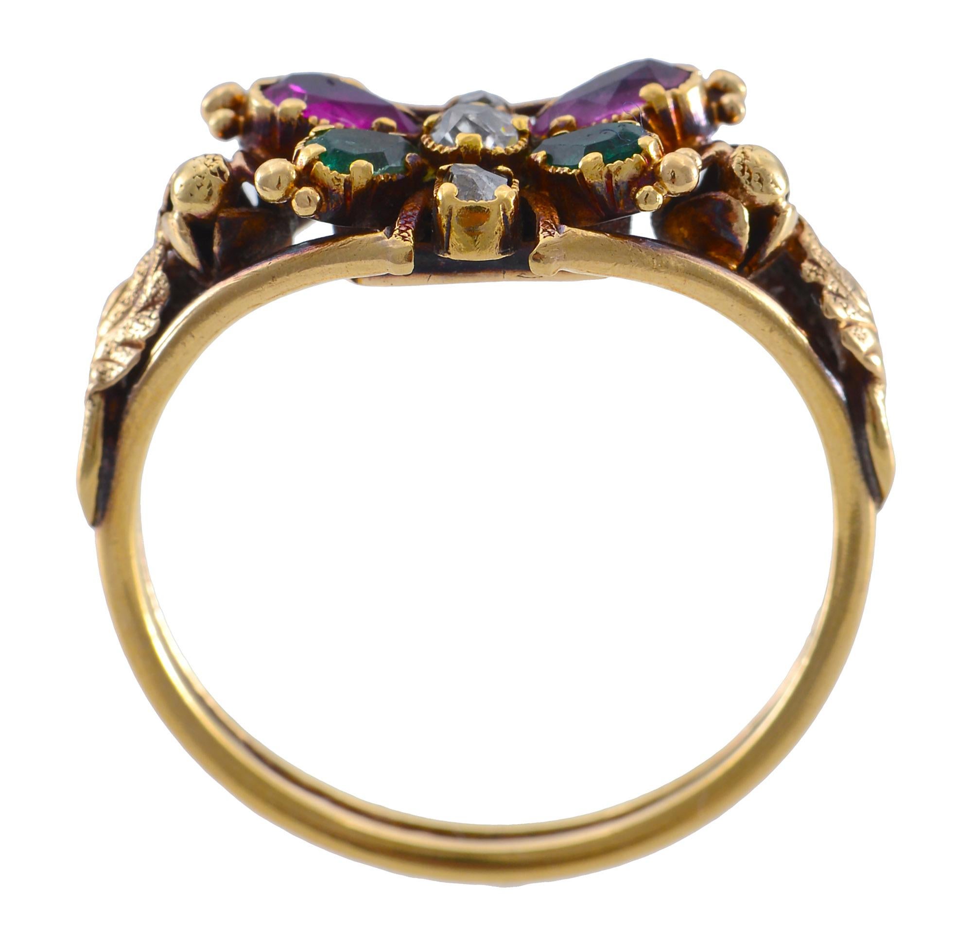 This sublime Georgian Circa 1830 Butterfly ring is set with multi coloured stones  and  a centre diamond in yellow gold with a  foiled and closed back settings as used in the Georgian period .The back of the ring contains a glazed compartment