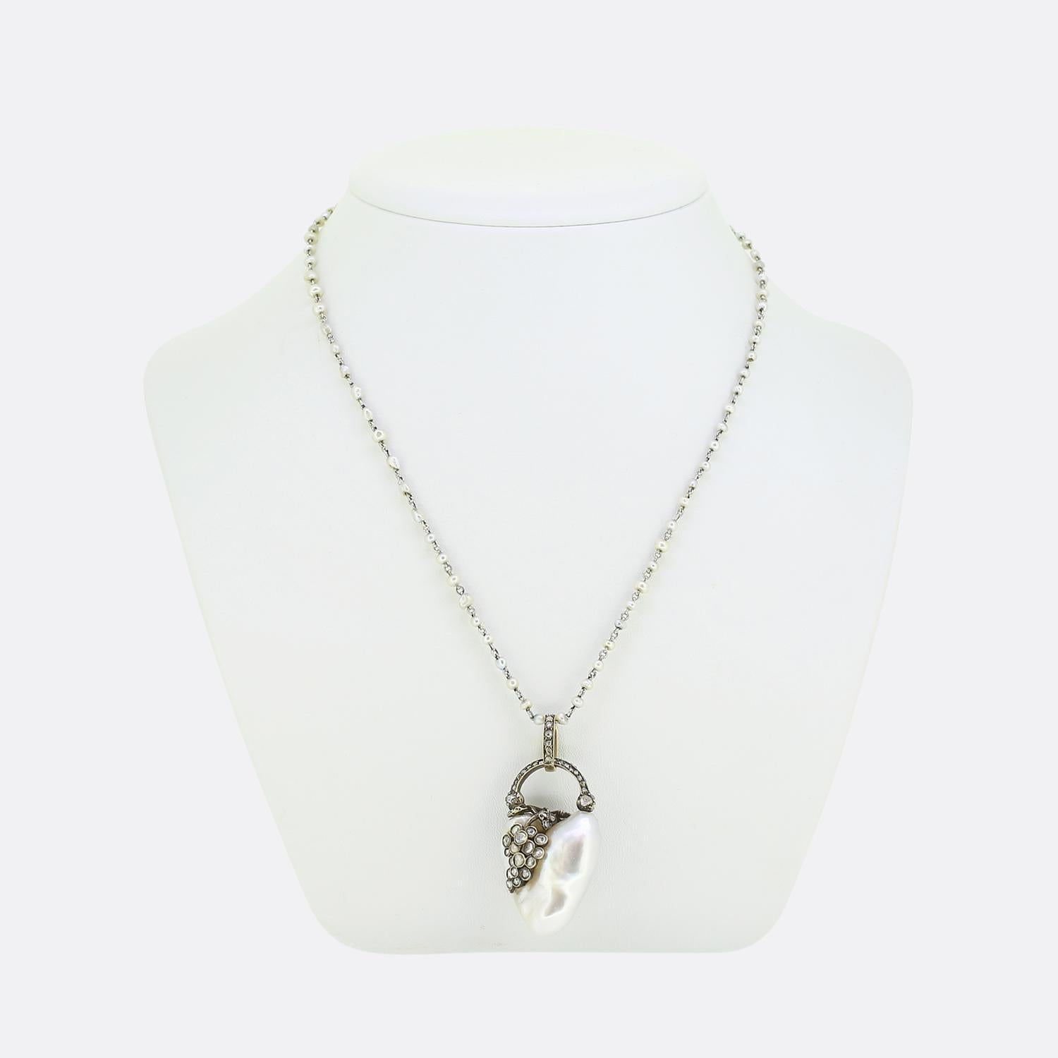 Here we have a Georgian necklace featuring a remarkable heart-shaped natural saltwater white pearl as the primary stone. This focal baroque pearl is adorned with a wrap around foliated design consisting of shimmering rose-cut diamonds which nestles