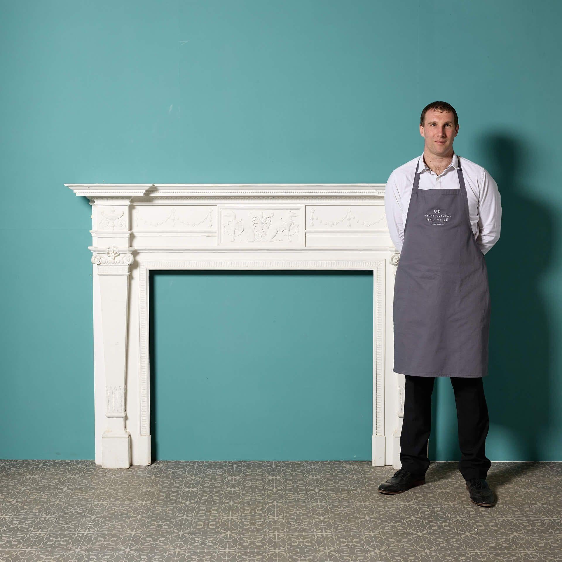 A painted Georgian neoclassical style fire mantel dating from around 1870. This impressive, large scale fire surround is crafted in pine and ornately decorated with composition embellishments, including Egyptian style carvings to the central tablet,