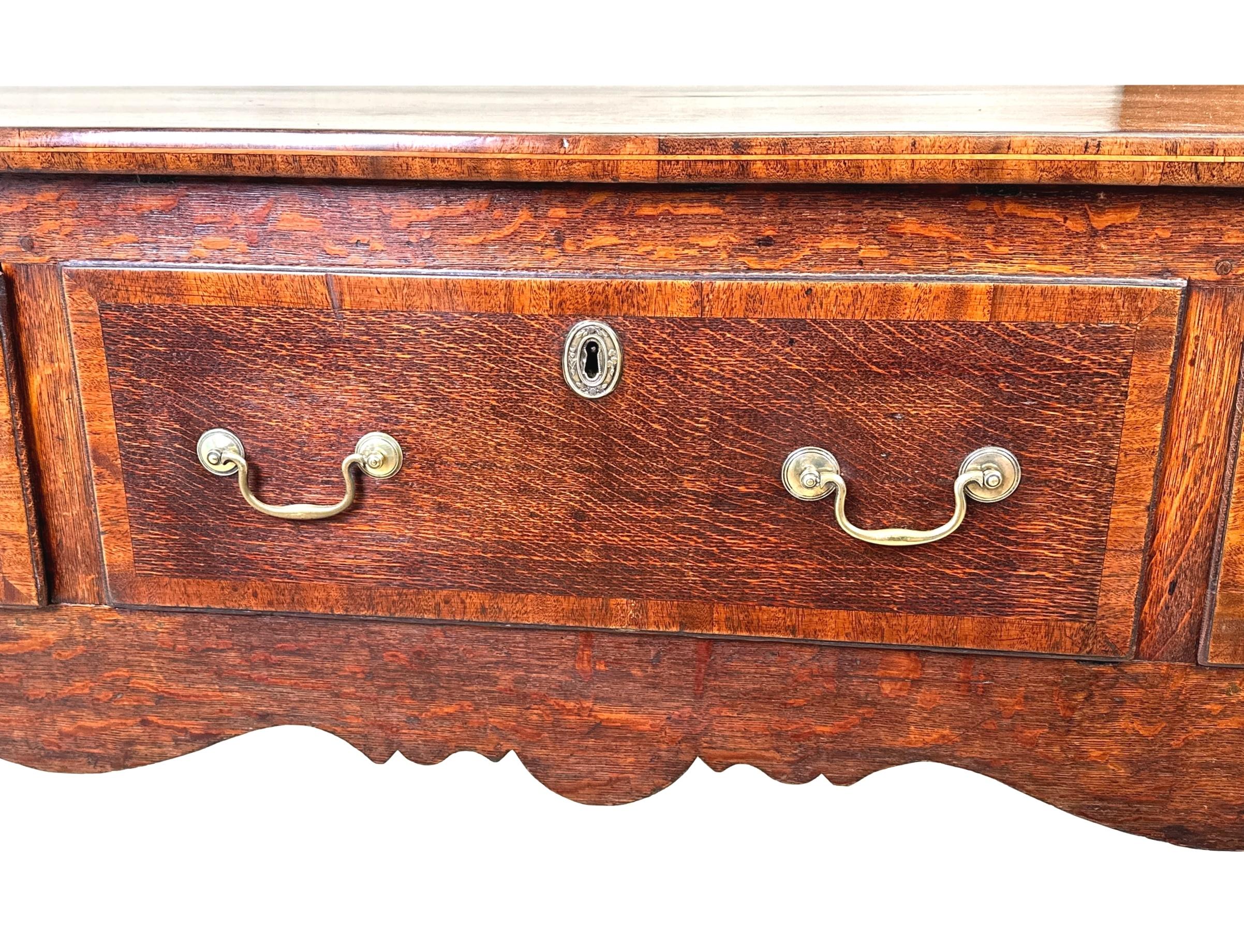 Credenza con base a cassettone in Oak Georgiano del XVIII secolo, di buona qualità e di grande fascino, con piano rettangolare e tre cassetti con maniglie originali a collo di cigno in ottone e decorazioni a fasce incrociate su un elegante grembiule