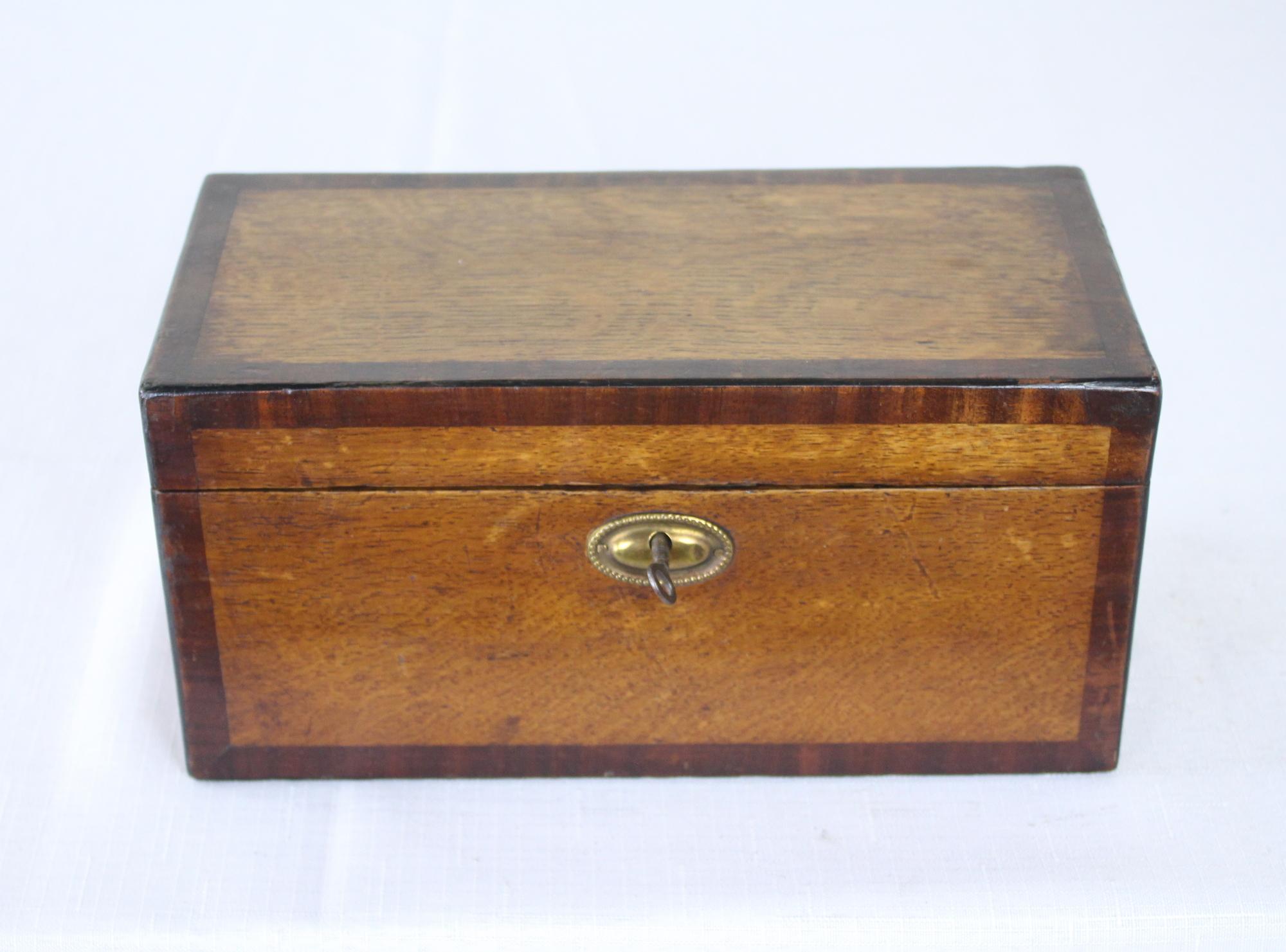 A beautiful Georgian tea caddy with original lock and key. Two compartments inside with traces of the original paper. Good oak grain and nice patina all over.