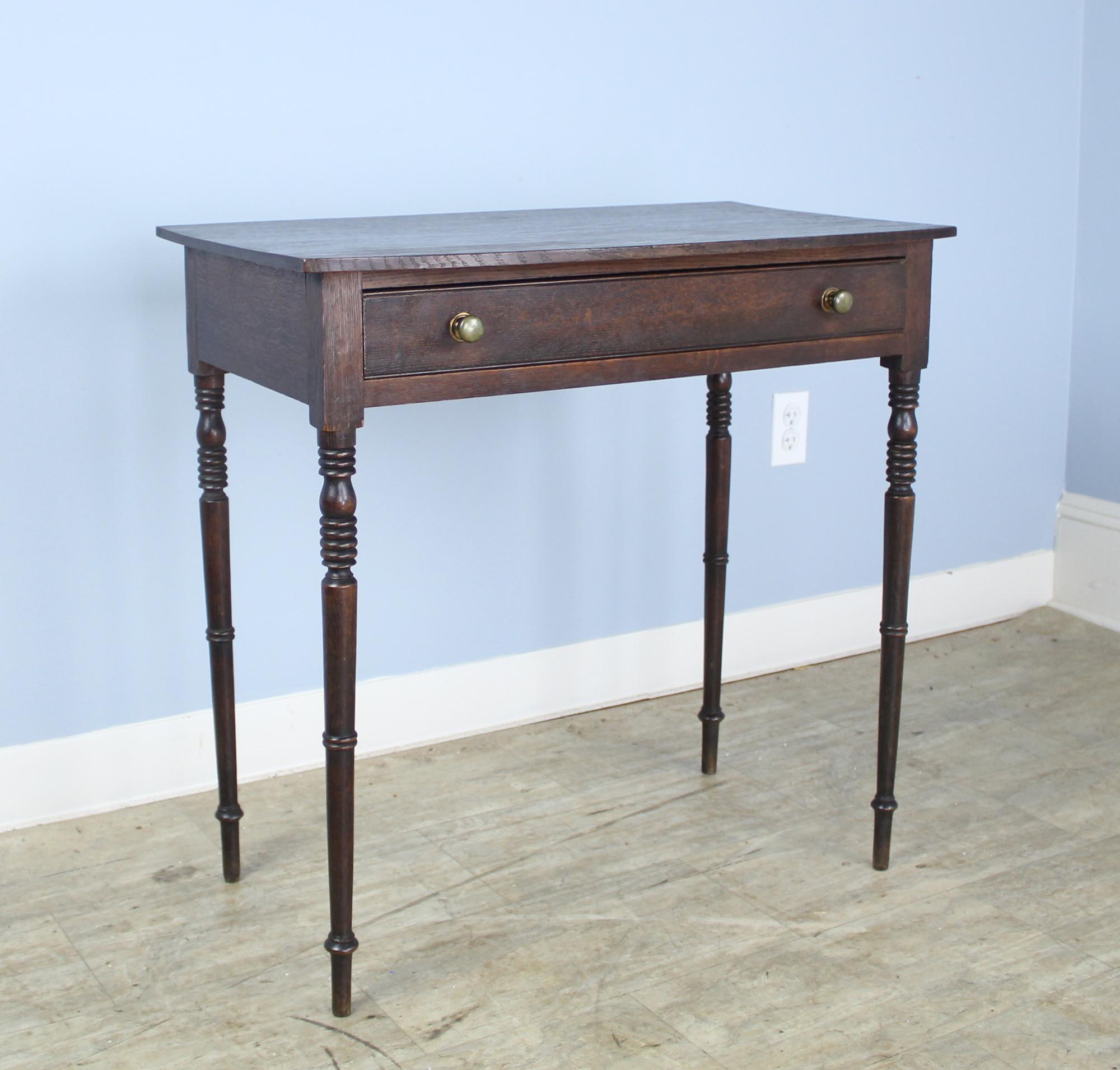 A graceful Regency side table with a bowed top and lovely thin turned legs in dark oak. The piece is in very good condition for it's age. Top has been lightly refinished.