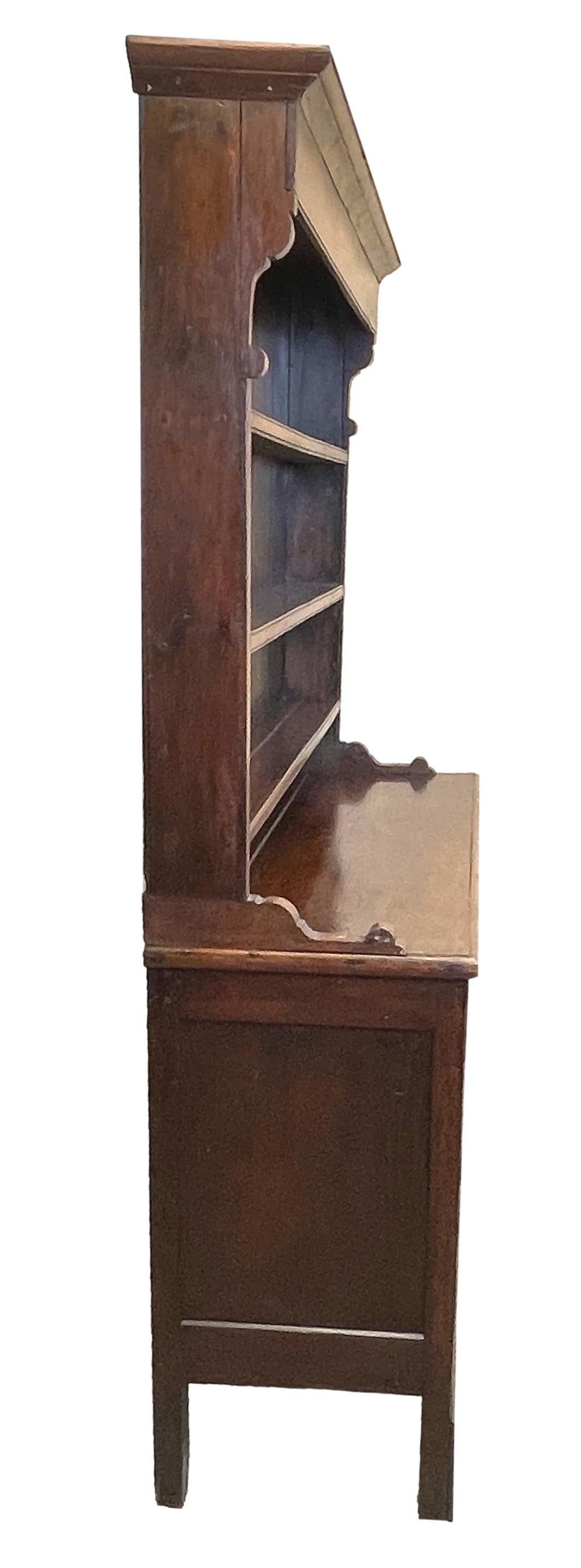Une commode de bonne qualité du début du 19ème siècle en chêne géorgien ayant un support original en forme de verrière avec trois étagères au-dessus de trois tiroirs à la frise et trois faux tiroirs flanqués de portes d'armoire à panneaux avec des