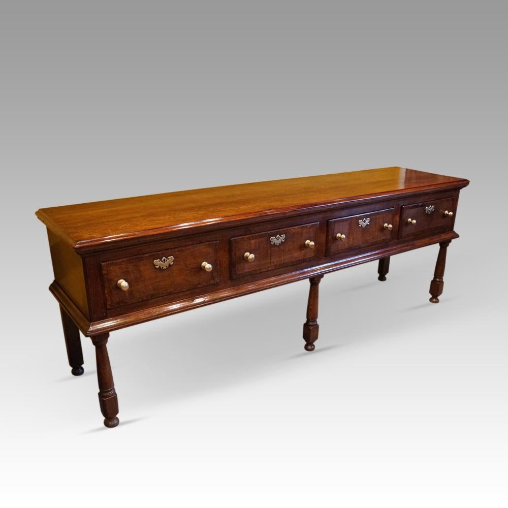 Long Antique oak dresser base 
This wonderful Antique oak dresser base was made circa 1780.
It is of a great size to fill an important area of your home.
Having the 3 turned legs to the front and 4 cross-banded drawers above.
The drawers with their