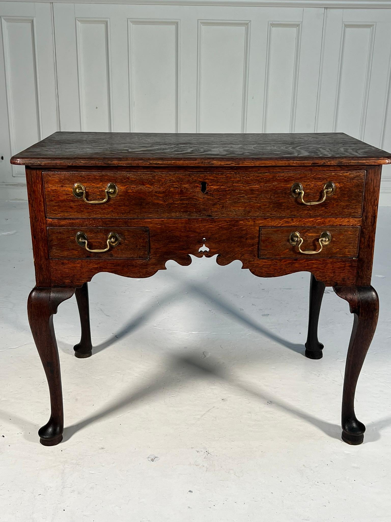 Georgian oak lowboy raised on cabrio legs, joined by a sweeping apron with some fretwork detail.

Wonderful patination to the timber, especially the top surface where the vibrant medullary rays pop from the dark quarter sawn oak.

Height 72cm
Width