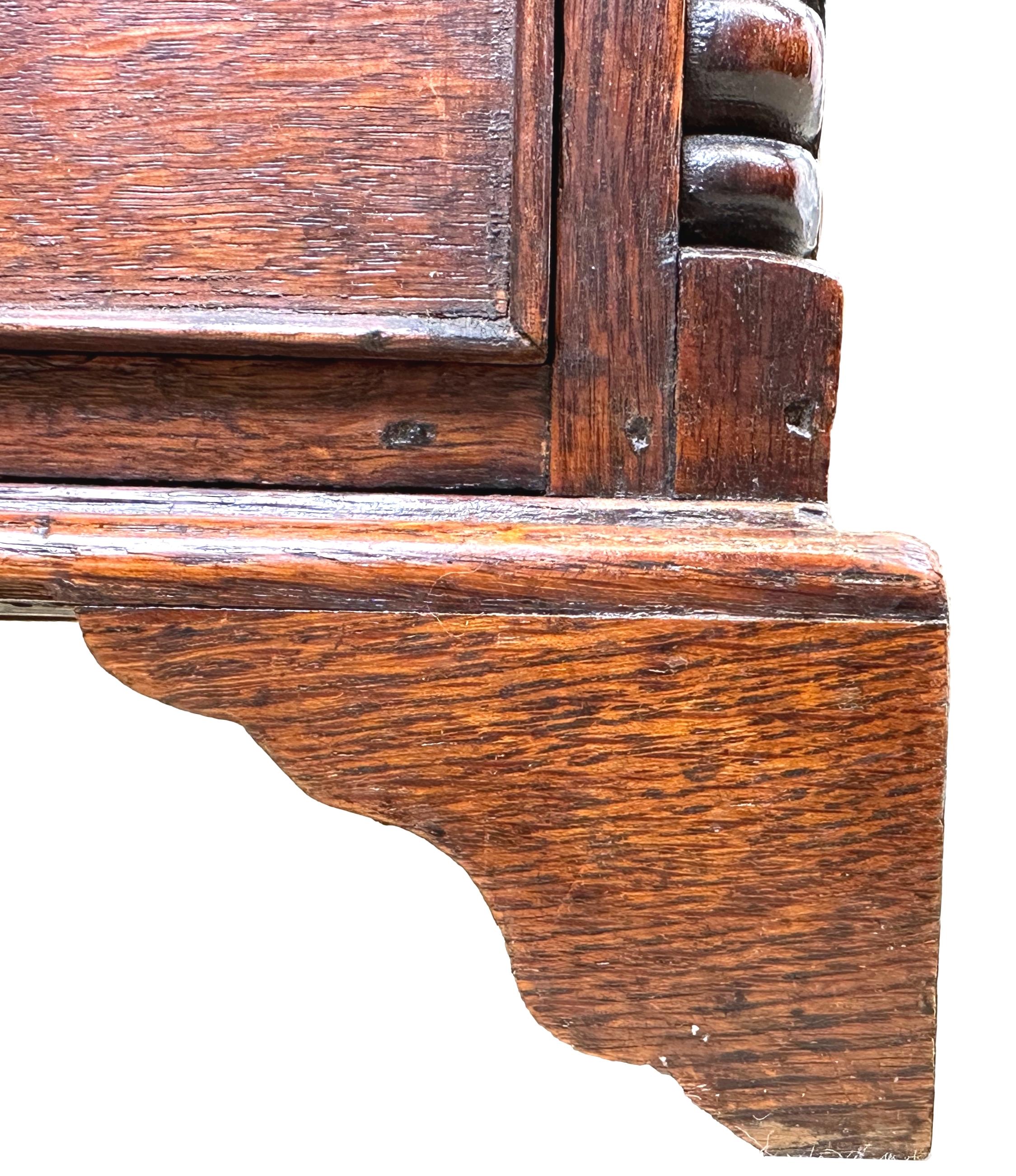 An extremely attractive and very good quality late 18th century, Georgian, oak miniature chest, having well figured rectangular top, over two short and three long drawers retaining original turned wooden knobs, flanked by elegant half turned