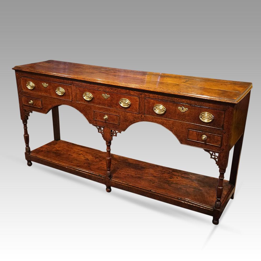 Antique oak pot board dresser base 
Here we are delighted to offer you this George III oak pot board dresser base.
It is fitted 3 drawers under the top and a small candle/spice drawers to each side of the arched frieze and a dummy drawer to the