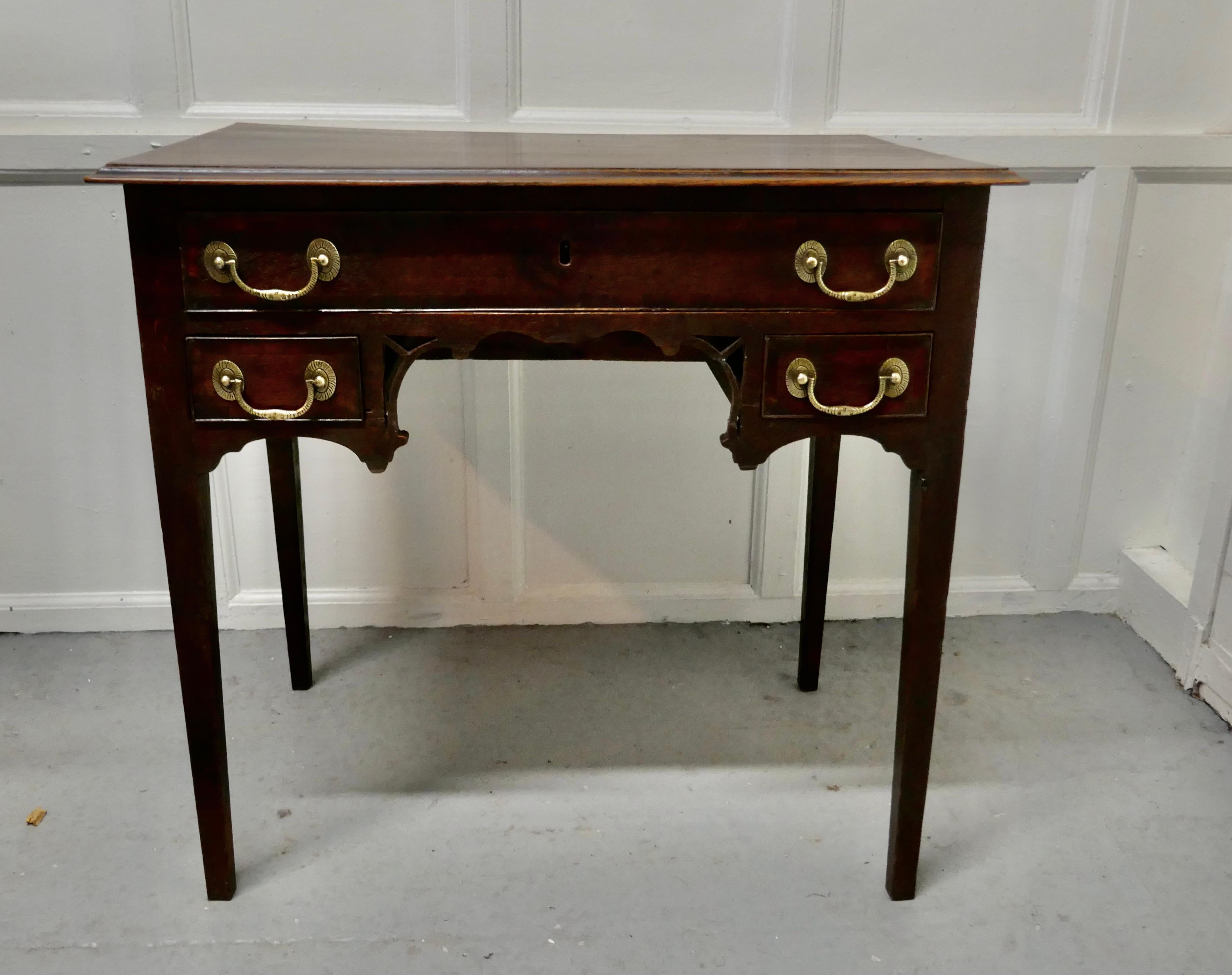 Georgian Oak Side Table or Writing Table

 A Georgian Country Oak Lowboy, this is a charming piece with a decorative kneehole to the centre front
The Low Boy stands on square slightly tapering legs it has a long drawer and 2 short drawers beneath on