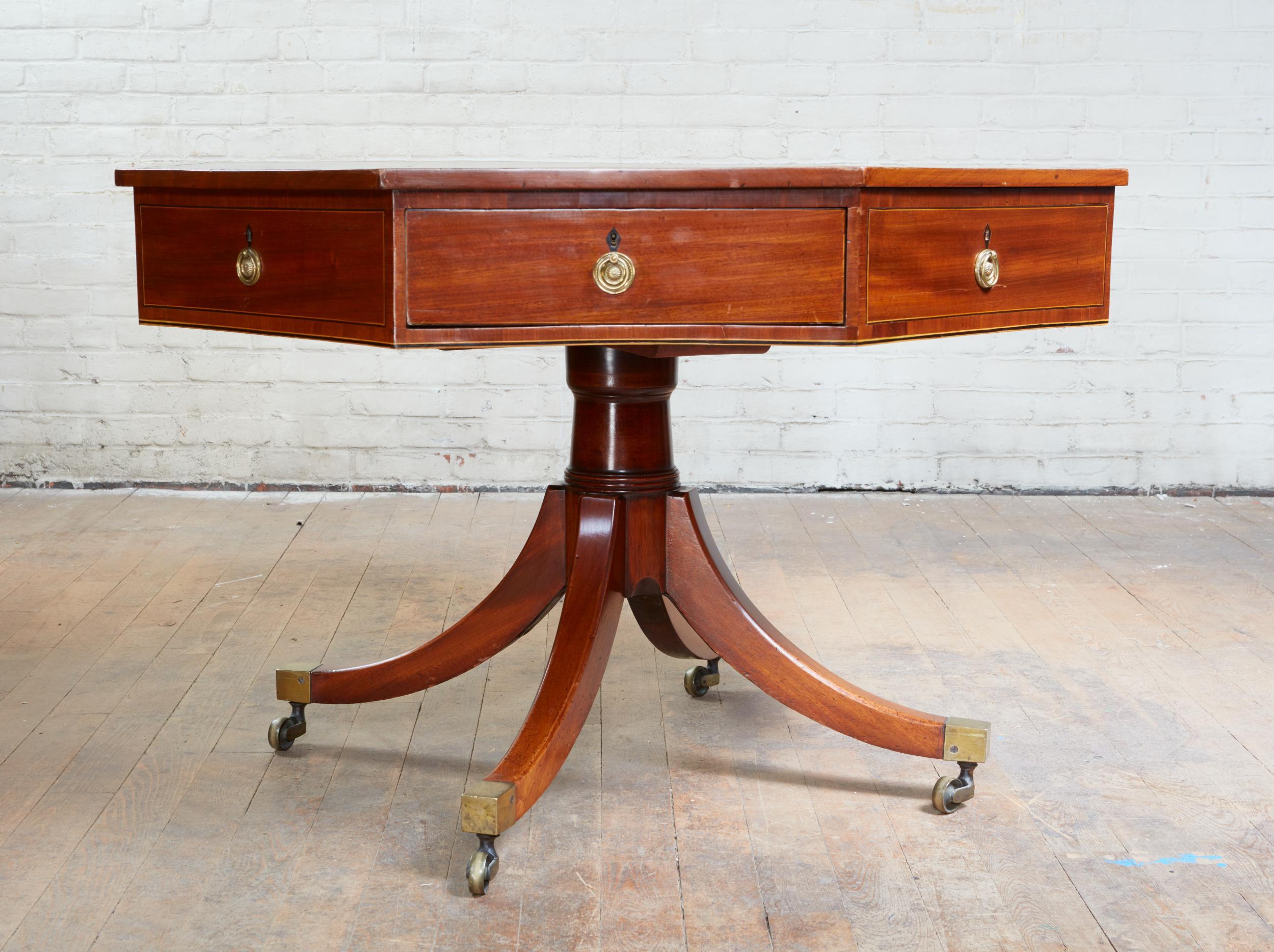 Fine George III mahogany octagonal library table, the bottle green leather top with gilt tooling over eight drawers (4 dummies) having ebony inlaid escutcheons and original brass handles and with cedar linings, standing on balustrade turned shaft