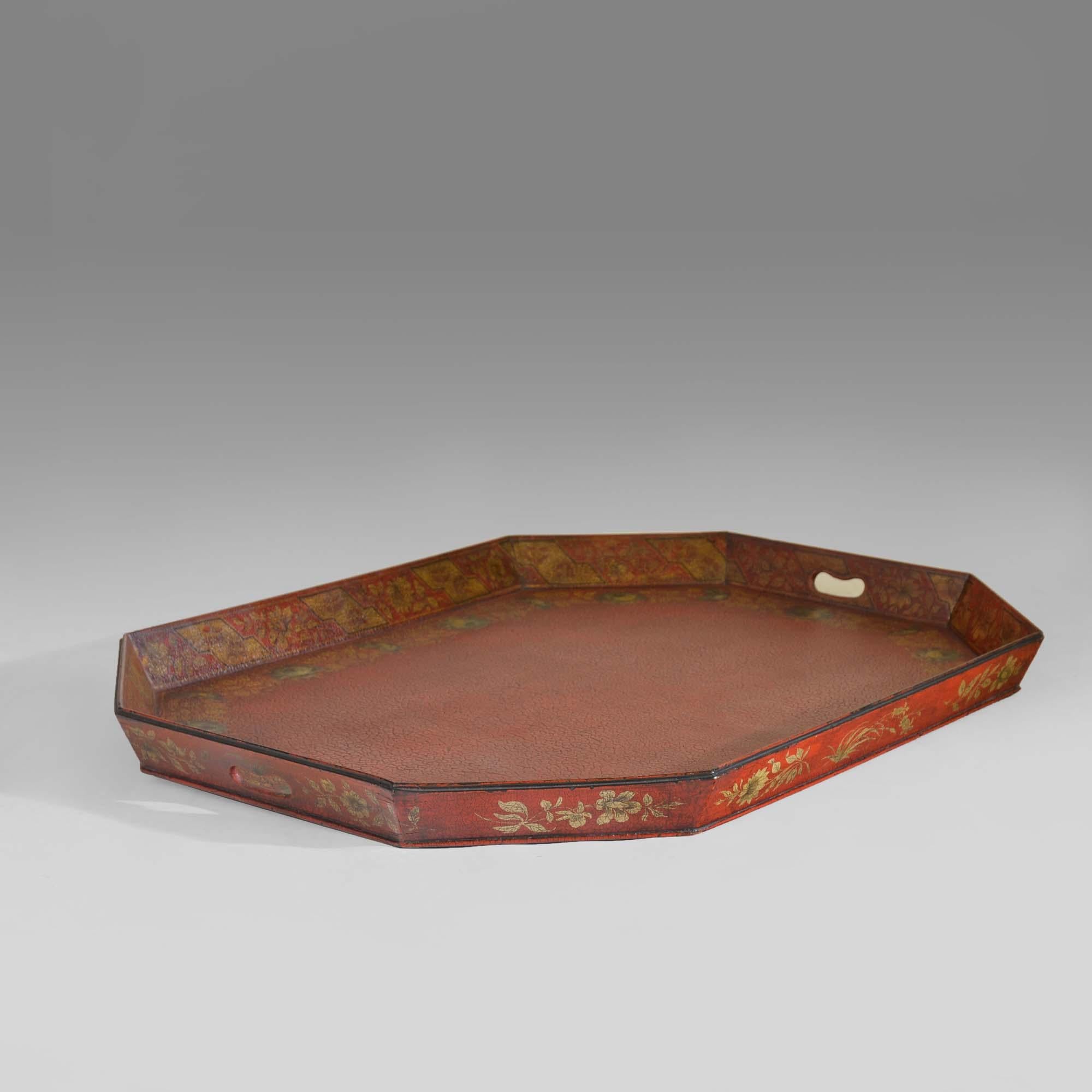 George III octagonal scarlet papier maché tray 
With gilt chinoiserie decoration and borders in 'India Rose' design, the underside inscribed with instructions to the decorator '32 Crimson Edge, India Rose Bottom, CE'. The raised canted sides pierced