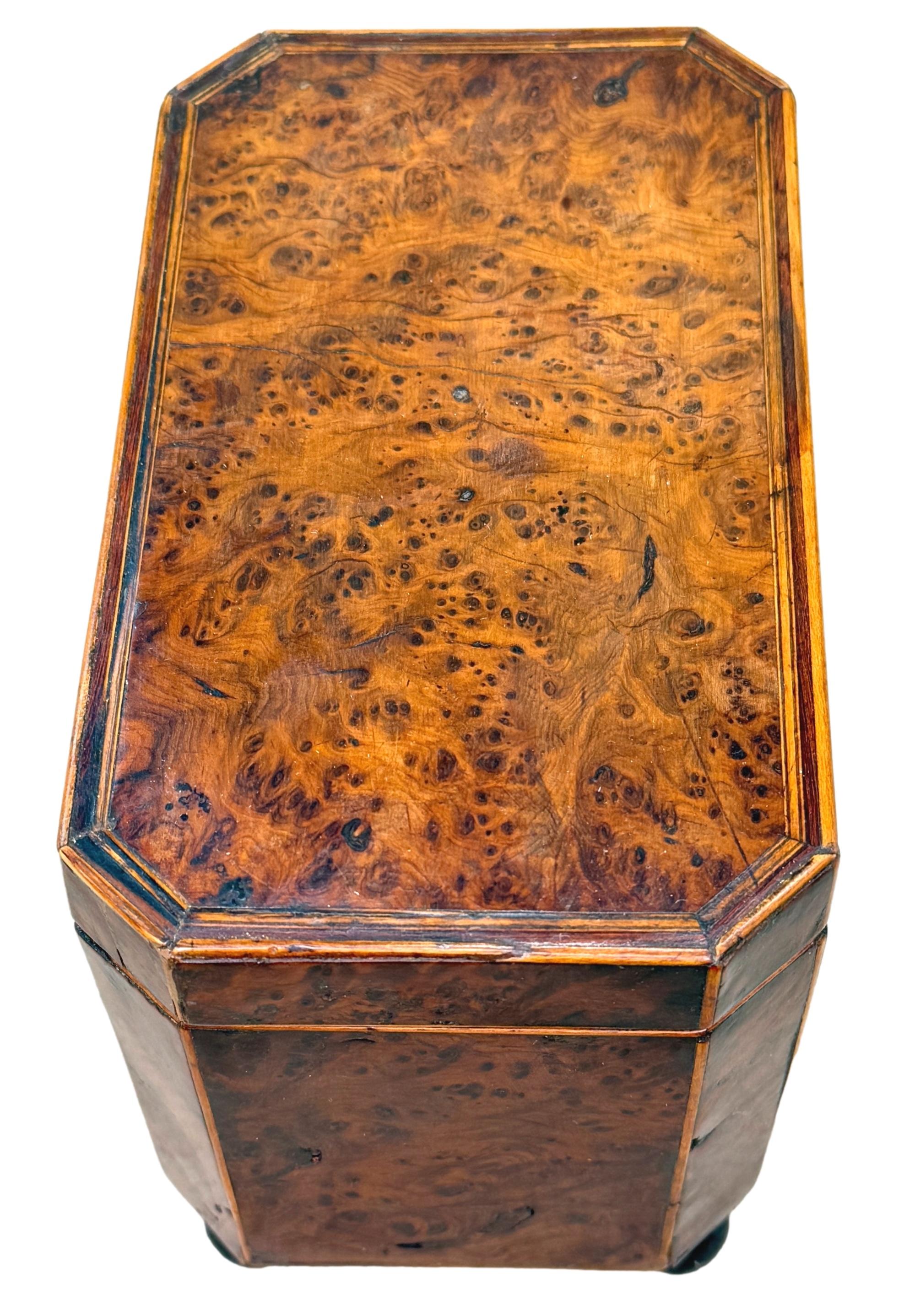 

Boite à thé en loupe d'if de forme octogonale du début du 19e siècle, d'époque George III, avec des placages superbement figurés et une décoration attrayante à l'aide de cordes, le couvercle à charnière renfermant deux compartiments, le tout