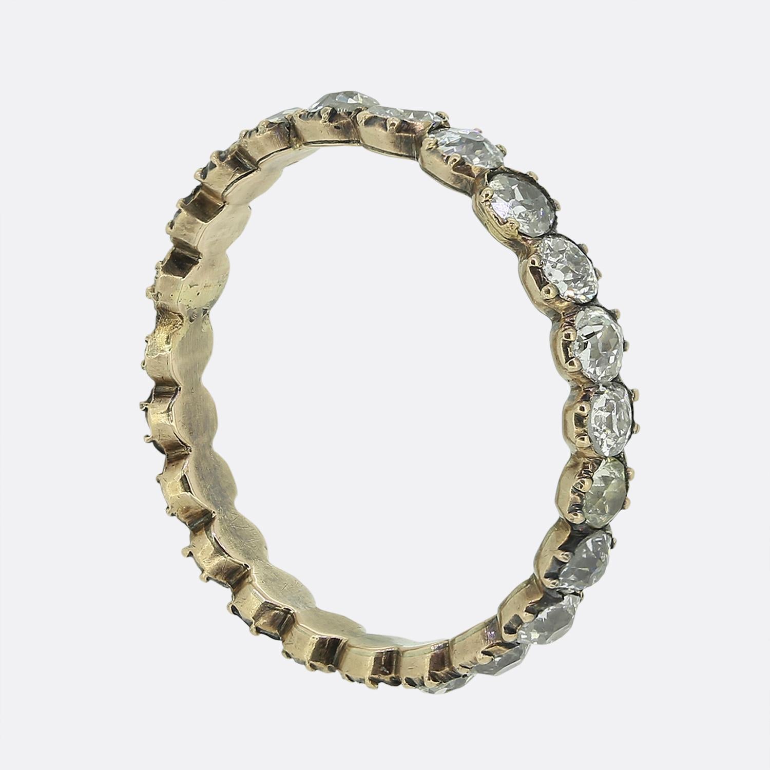 Aquí tenemos un exquisito anillo de eternidad de diamantes que data del periodo georgiano. Esta rara pieza antigua ha sido elaborada en oro viejo y presenta 22 relucientes diamantes de talla antigua en una formación de una sola línea. Todas las
