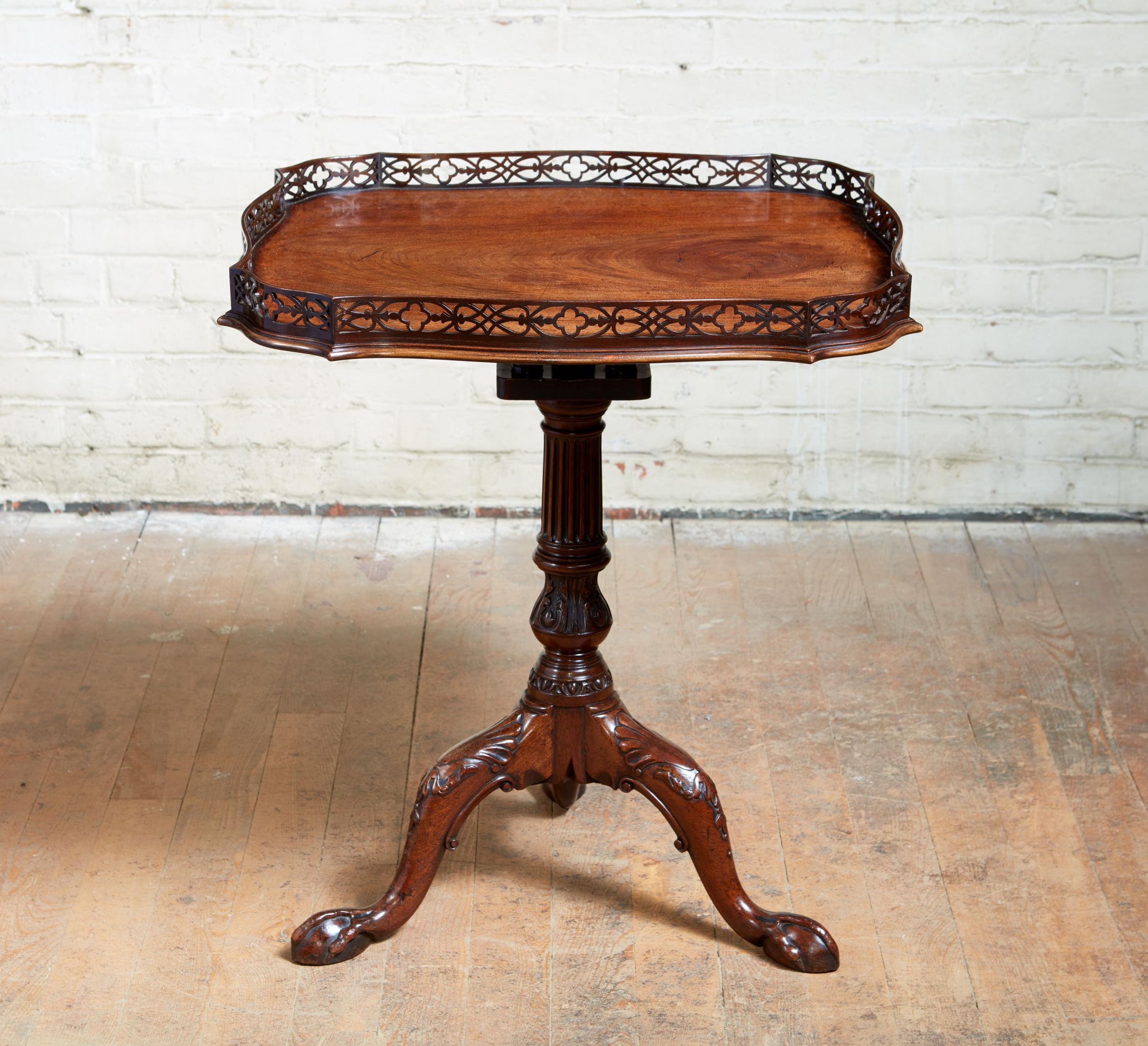 Fine George II padouk fretwork birdcage tilt-top tea table, the scalloped top with pierced fretted gallery over single plank top with molded and shaped edge over turned, fluted and carved shaft having acanthus leaf and egg and dart carving, the