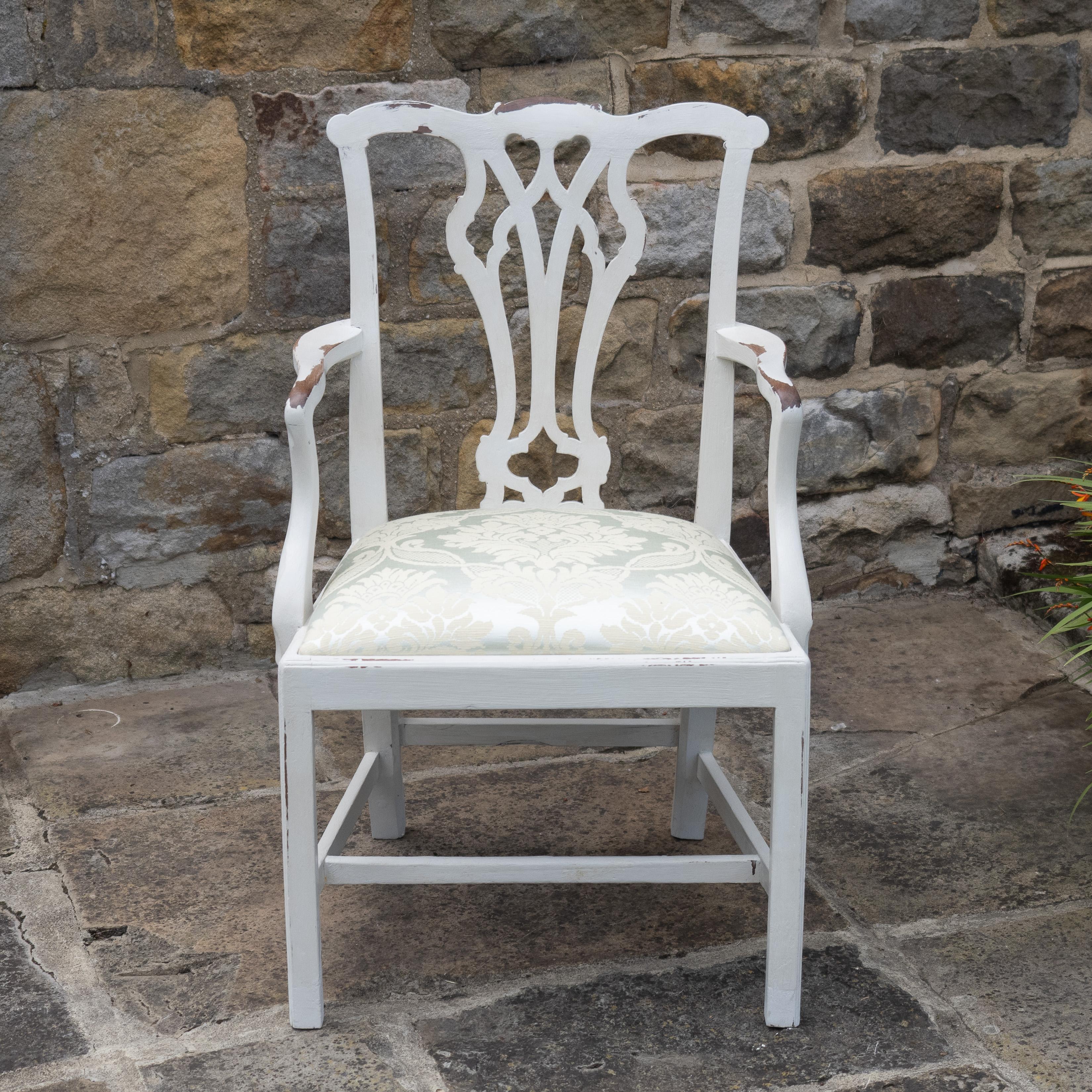 A Georgian period, late 18th century, painted mahogany elbow chair. This armchair in Chippendale taste, features a pierced back splat, drop-in upholstered seat, covered in a quality woven damask pale blue green fabric. Curved open arms. Square front
