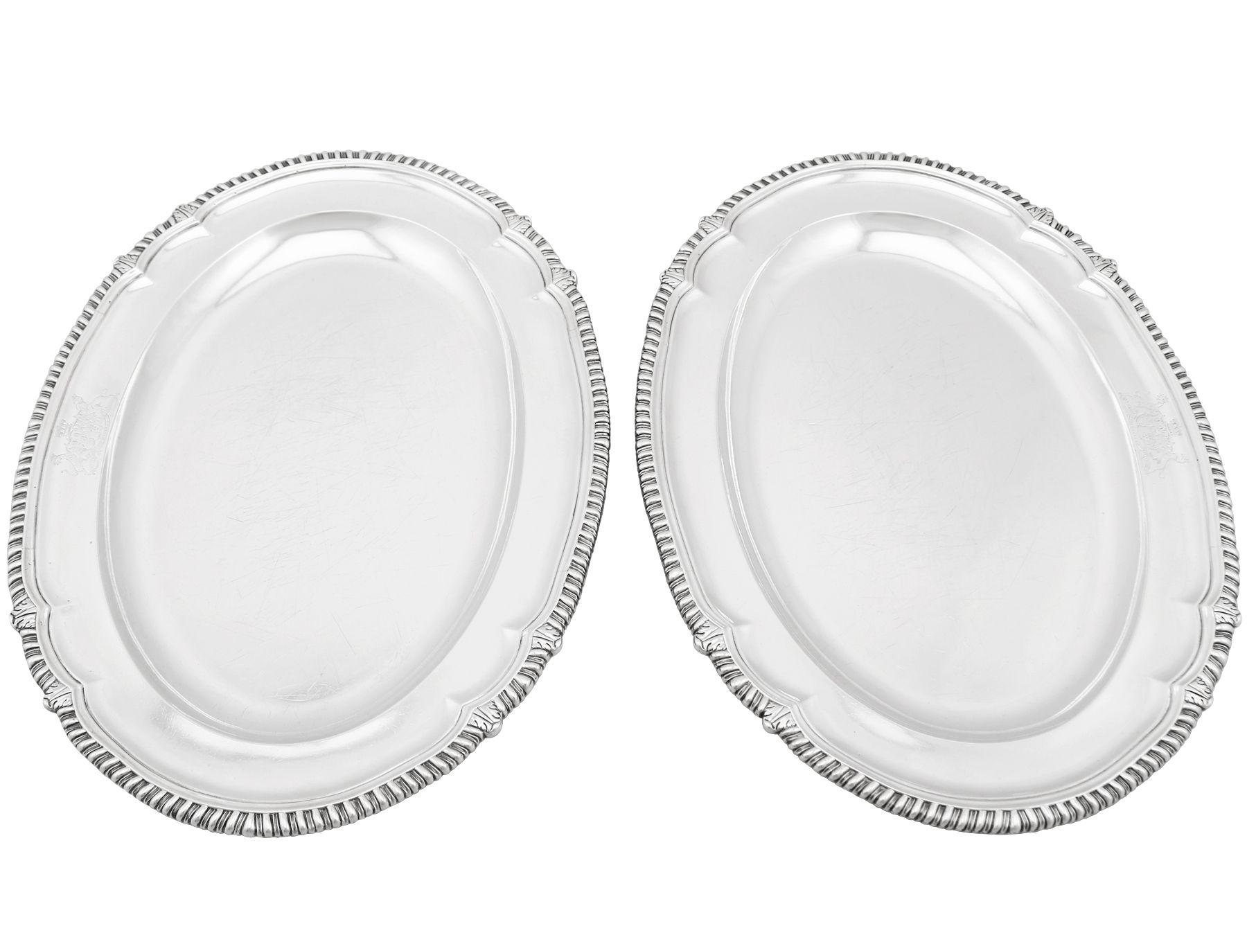 A fine and impressive pair of antique George IV English sterling silver meat platters; an addition to our silver dining collection.

These fine antique George IV sterling silver meat platters have an oval shaped incurved form with a sunken oval