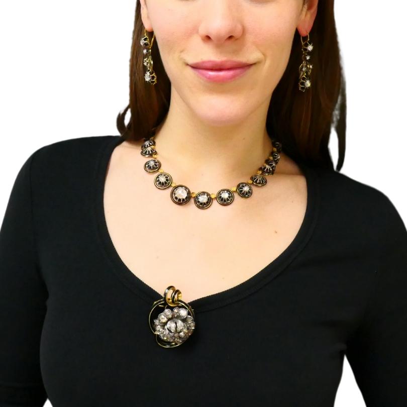 An antique Georgian parure set, made of gold and silver, featuring approximately 20 carats of rose cut diamonds. This impressive Georgian set includes a necklace, a pair of earrings, and a brooch. 
The antique necklace features a series of circular