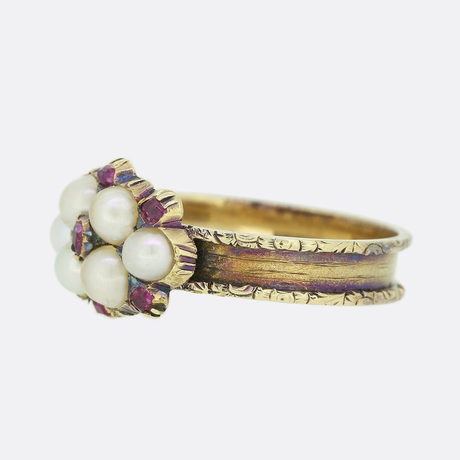 This is a beautiful Georgian 15ct gold pearl and ruby cluster ring. The central ruby is surrounded by four large natural half pearls which themselves are flanked by an additional single half pearl on either side. These focal stones are encompassed