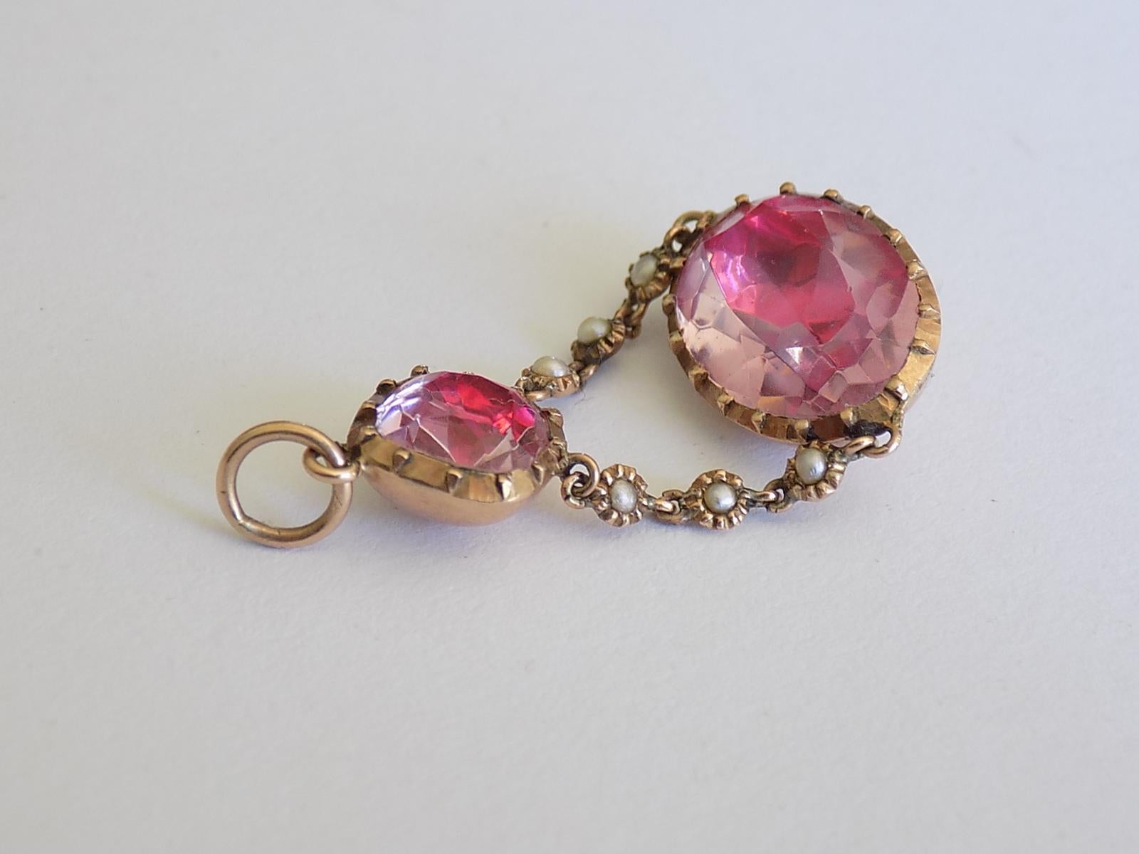 A Lovely Georgian c.1800 ( Carat Gold, split Pearl and Pink Topaz paste (glass) pendant. The paste in foil closed back setting. English origin. Rare find.
Drop 37mm, width 20mm.
Weight 3.7gr.
Unmarked, tested 9 carat gold.