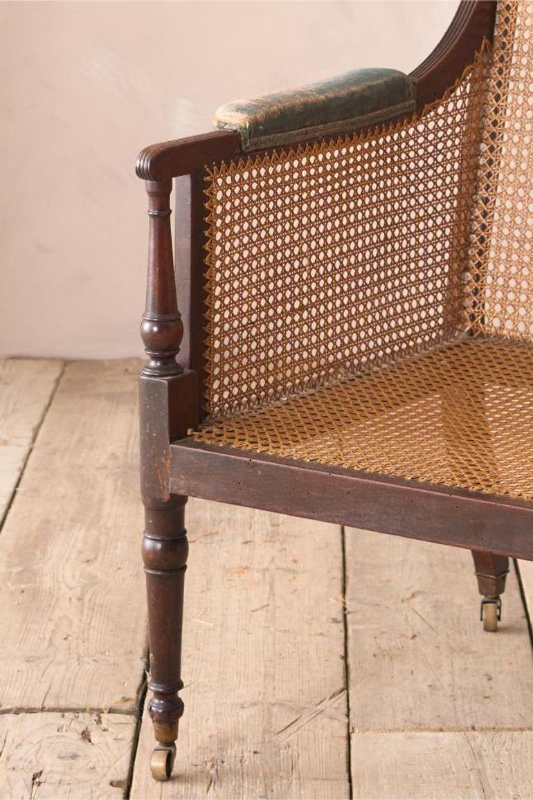 This is a fabulous quality Georgian period bergere library chair with wonderful reeded details to the frame. Standing on tall turned legs with elegant arm supports. Lovely proportions and in very nice original condition. Even down to the brass