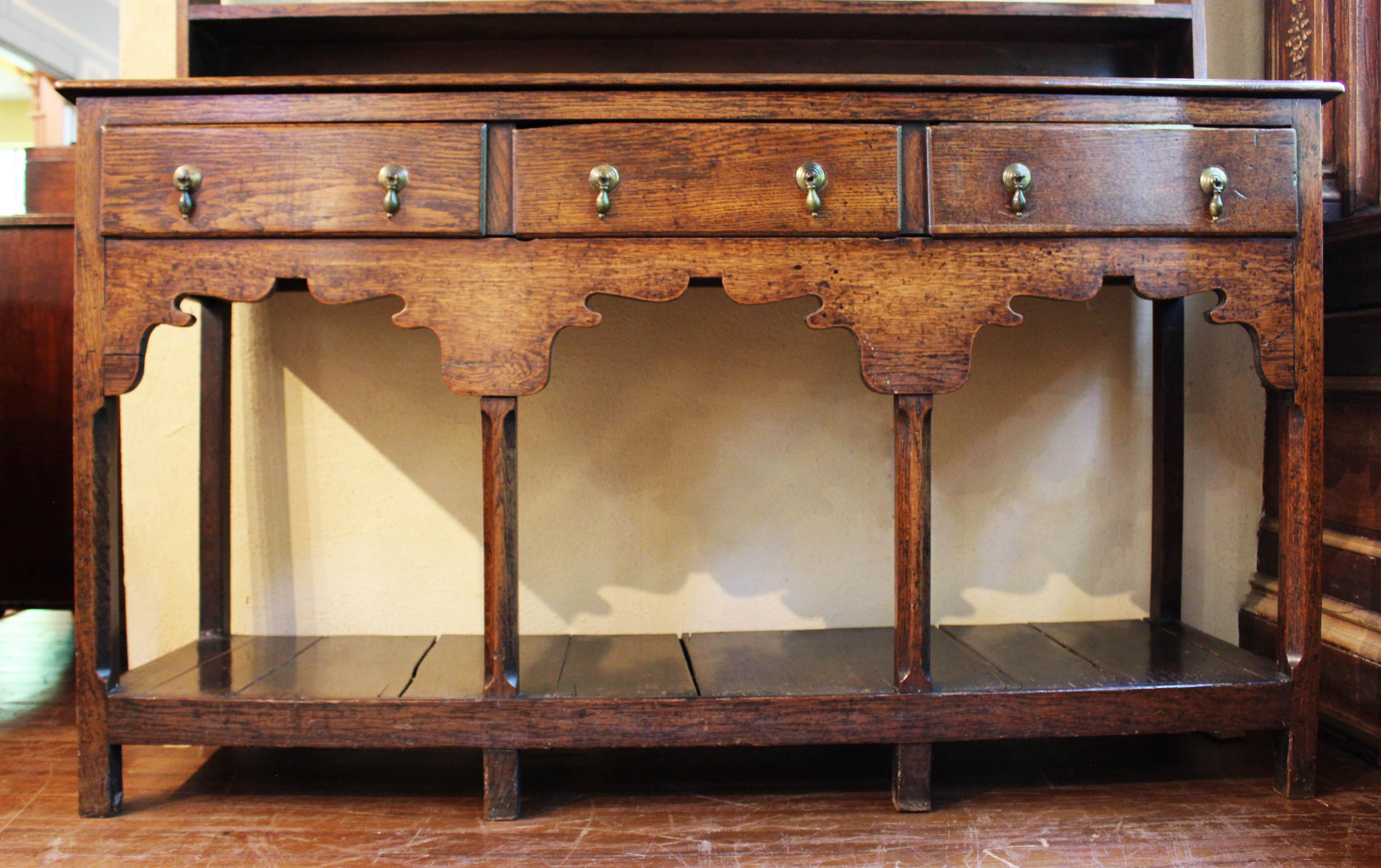 Georgian Period, c.1780, small oak dresser with plate rack from Kent, English. The upper plate rack section with 3 shelves plus base shorter shelf, each with plate rails, and with hooks for cups. Original crown molding. The dresser base with