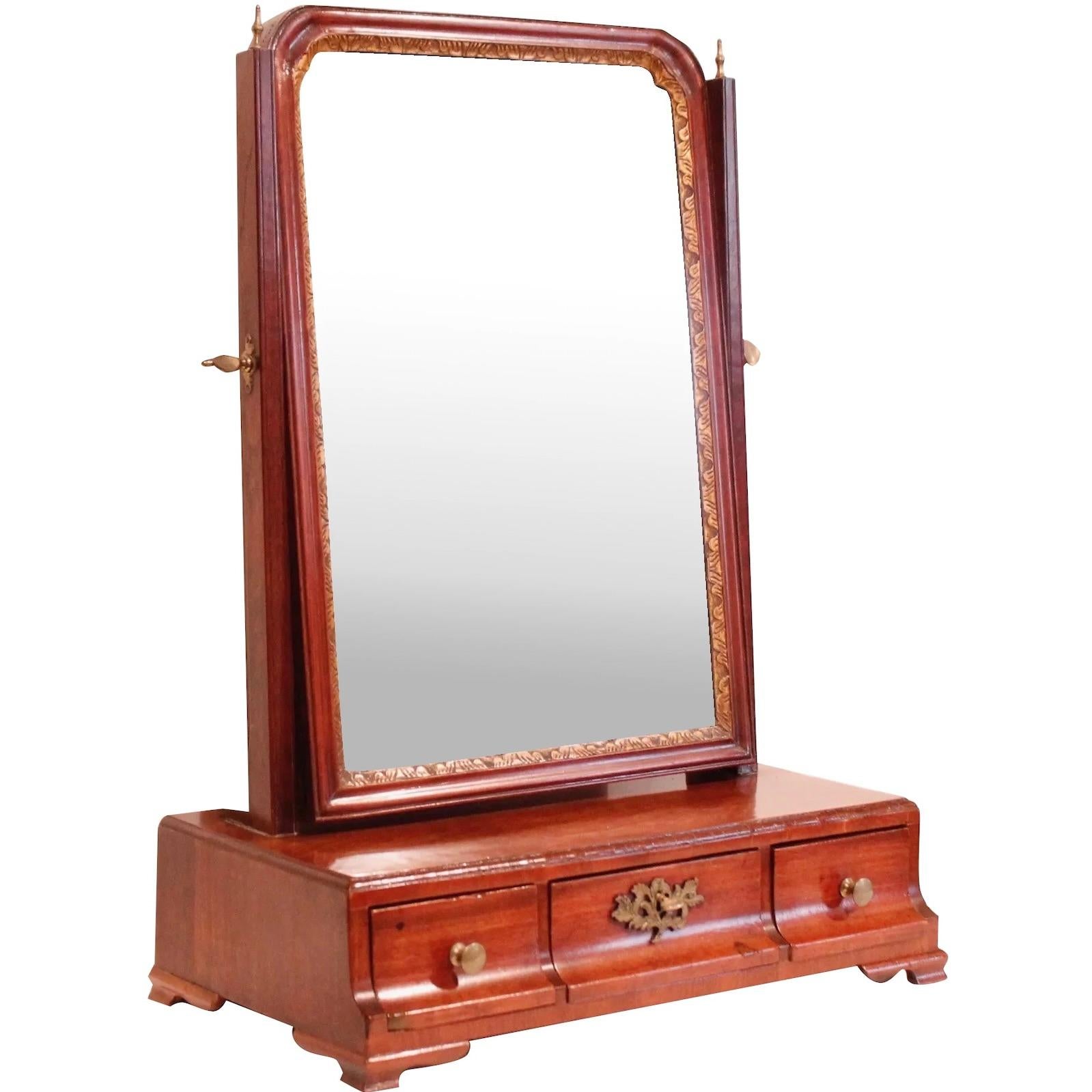 A George II/George III walnut mirror on stand, the stand on bracket feet with three drawers, and mirror panel that pivots. Retains original hardware with a particularly nice central brass escutcheon plate. Ca. 1760-1780. Original mercury glass