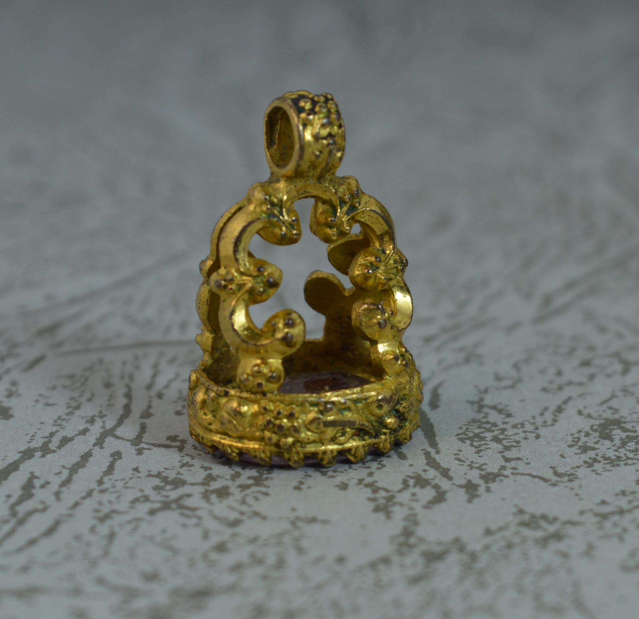 A true antique fob seal intaglio pendant. c1830.
Pinchbeck example.
Set with an oval amethyst to the base. Hand carved intaglio with a cherub.

Condition ; Very good. Crisp design. Well set stone, crisp intaglio. Please view photographs.
Hallmarks ;
